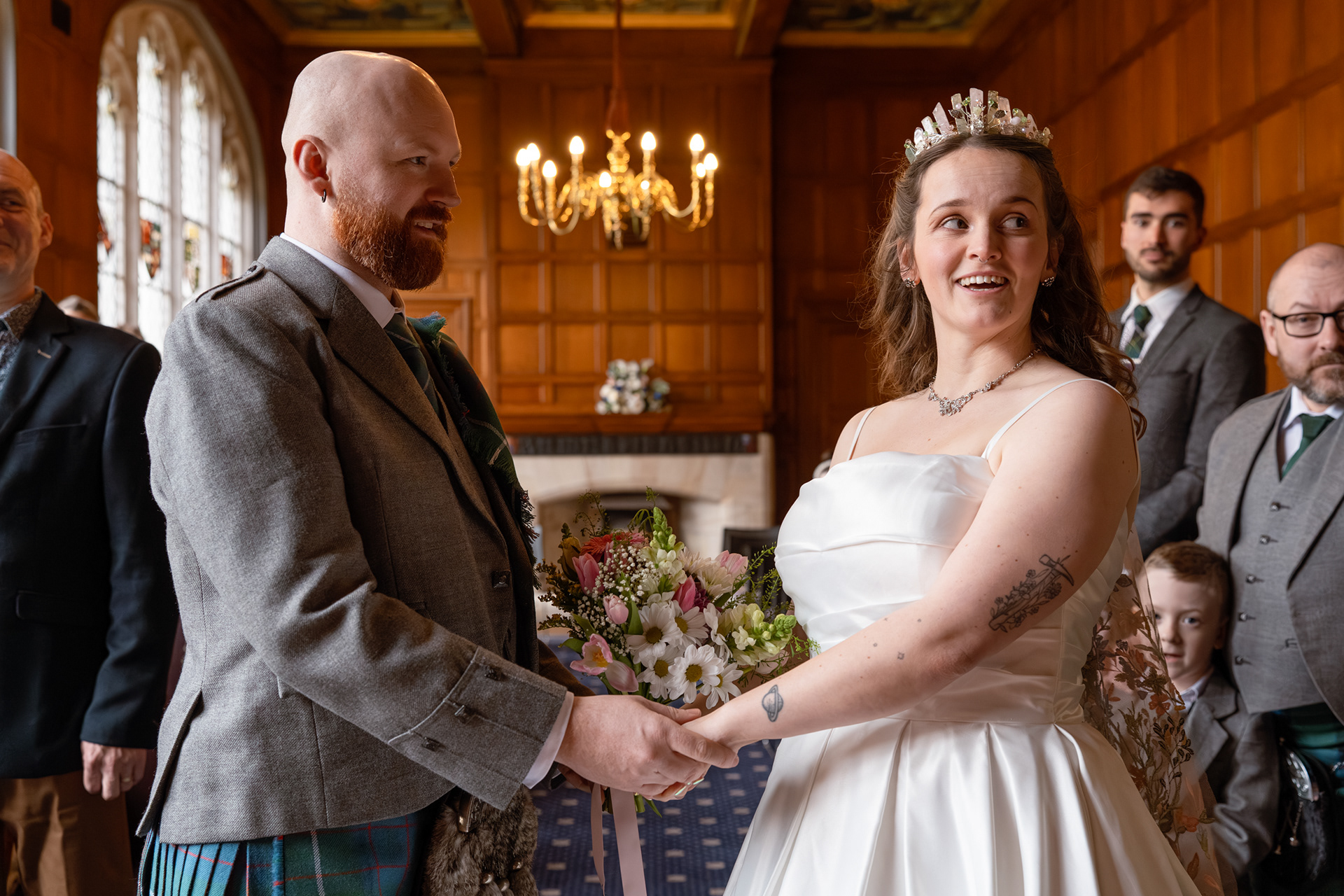 Bride and groom hold hands and prepare to exchange vows during their Aberdeen registry office wedding.