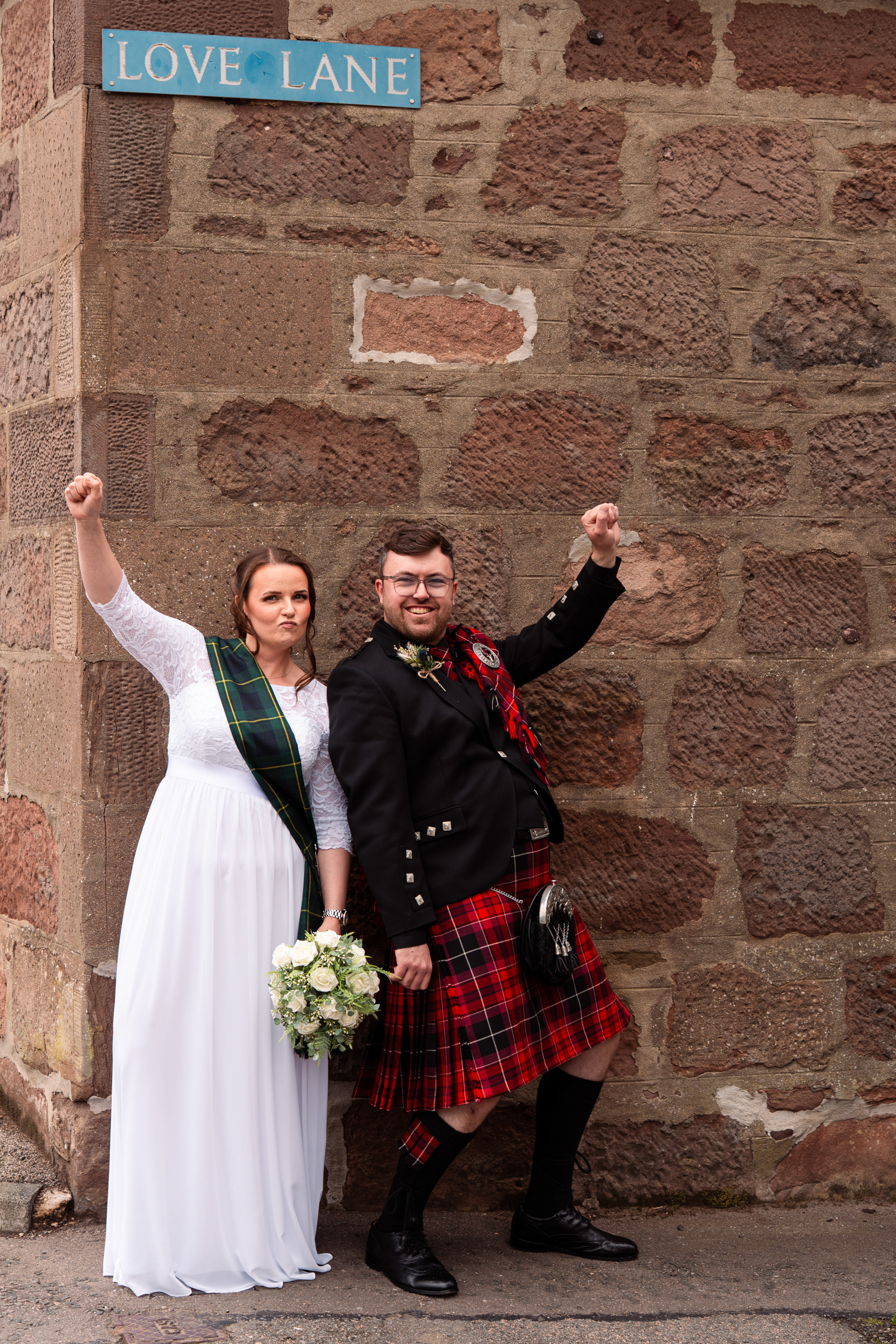 Stonehaven wedding: the classic fist pump under the Love Lane street sign shot. It has to the be done.