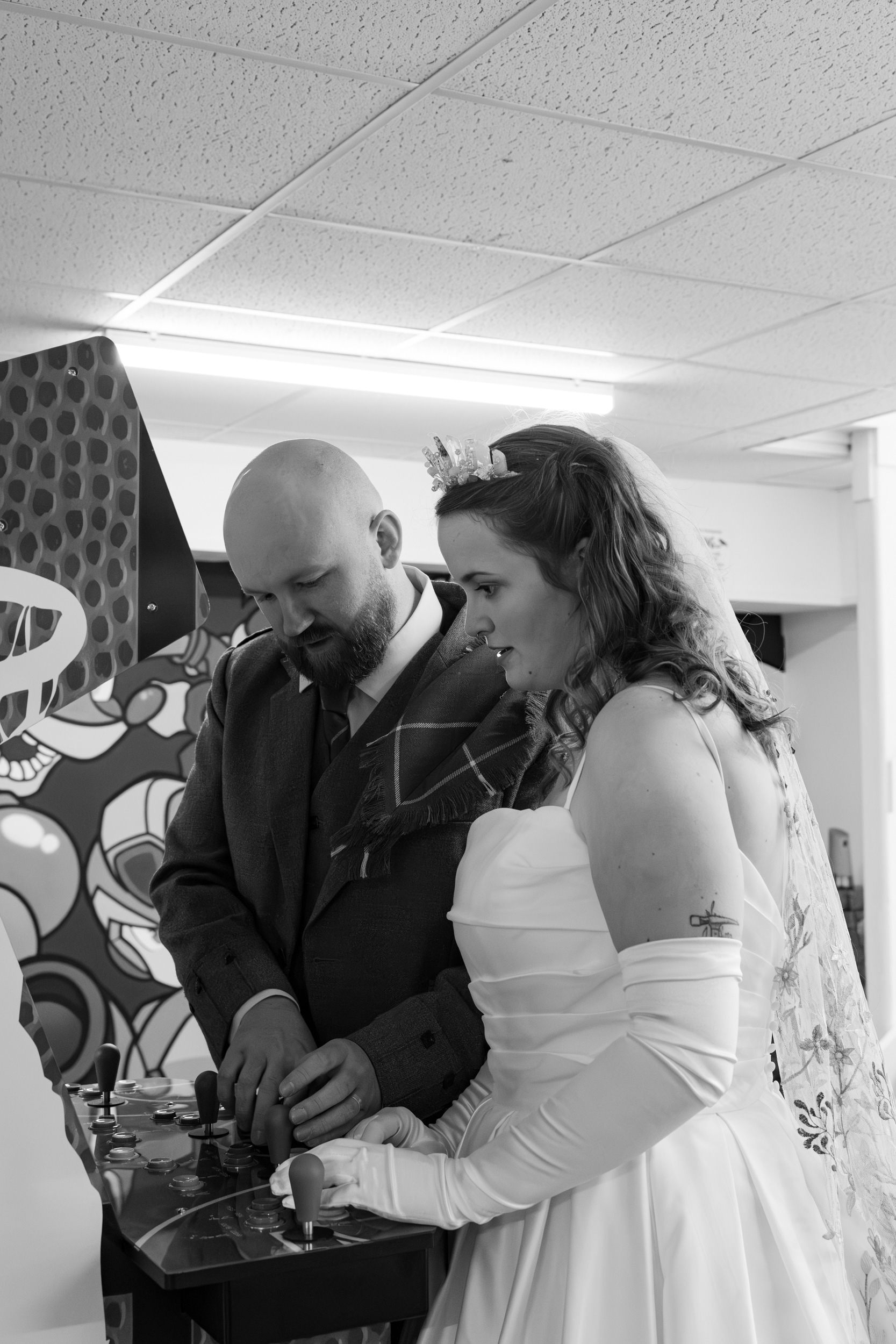 Alternative Aberdeen Wedding Photography: Newlywed couple play an arcade game together.