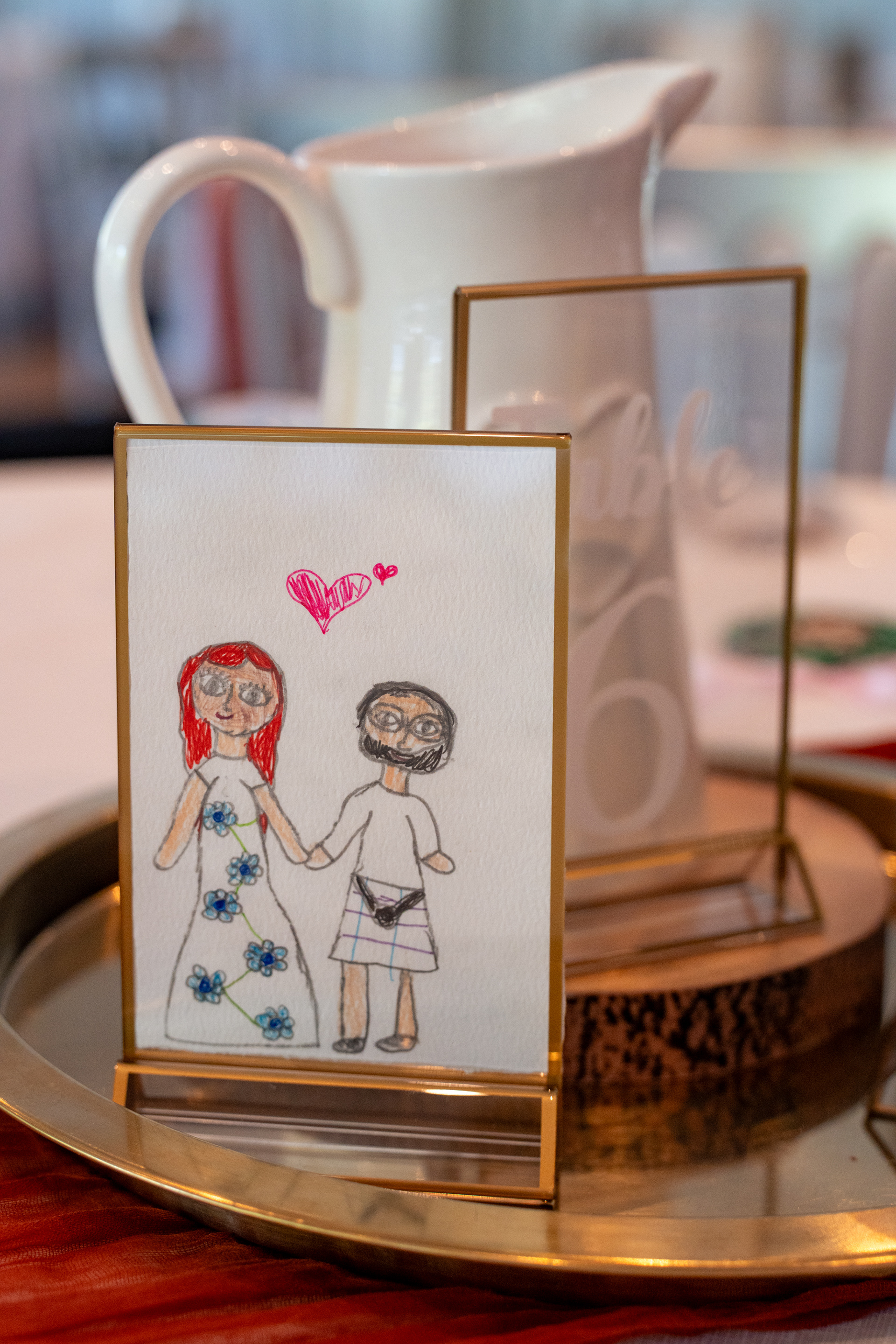 A drawing of the bride and groom, done by a primary four child, is framed and used as a table decoration.