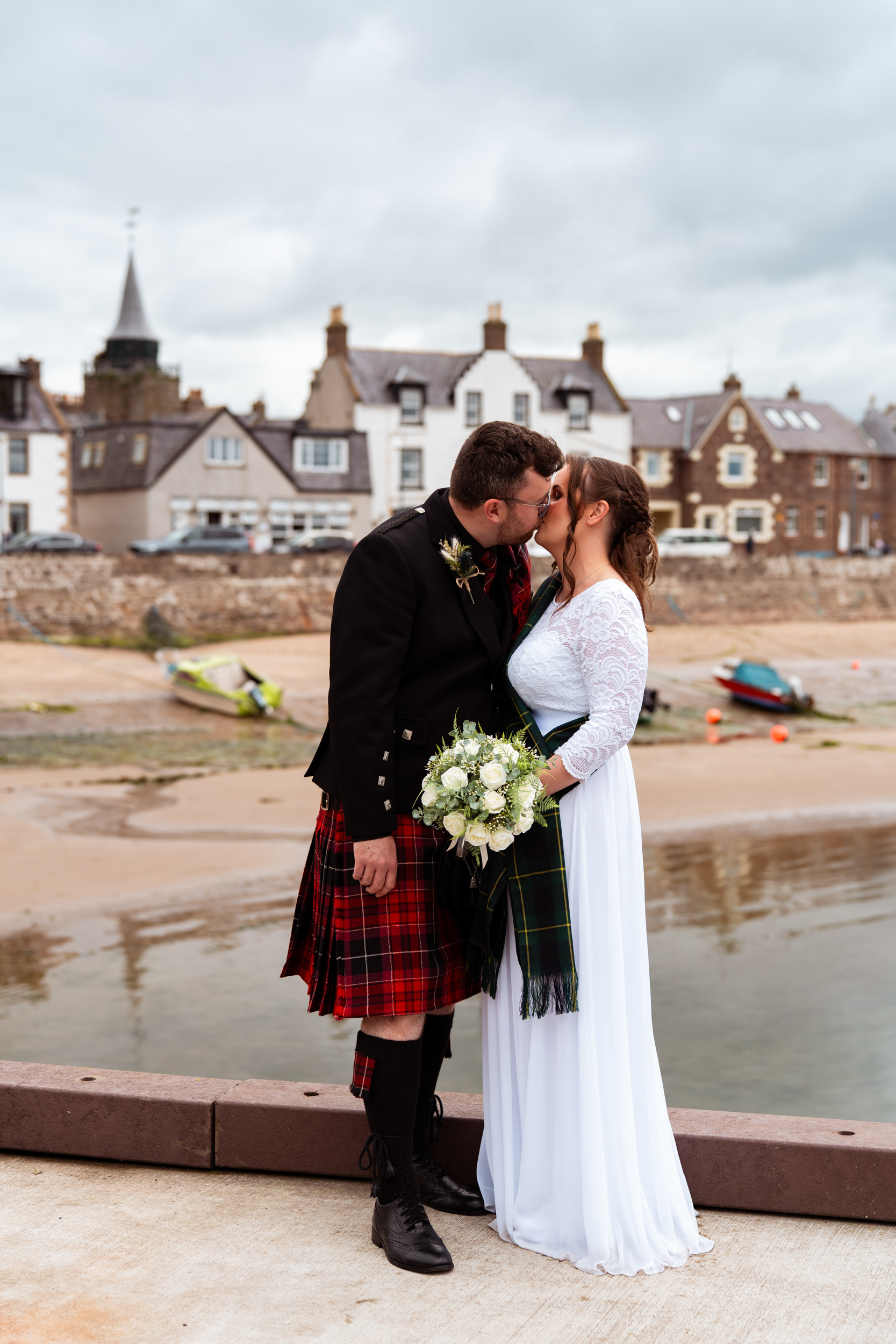 Aberdeenshire registry office wedding: Bride and groom kiss against a backdrop of Stonehaven harbour.