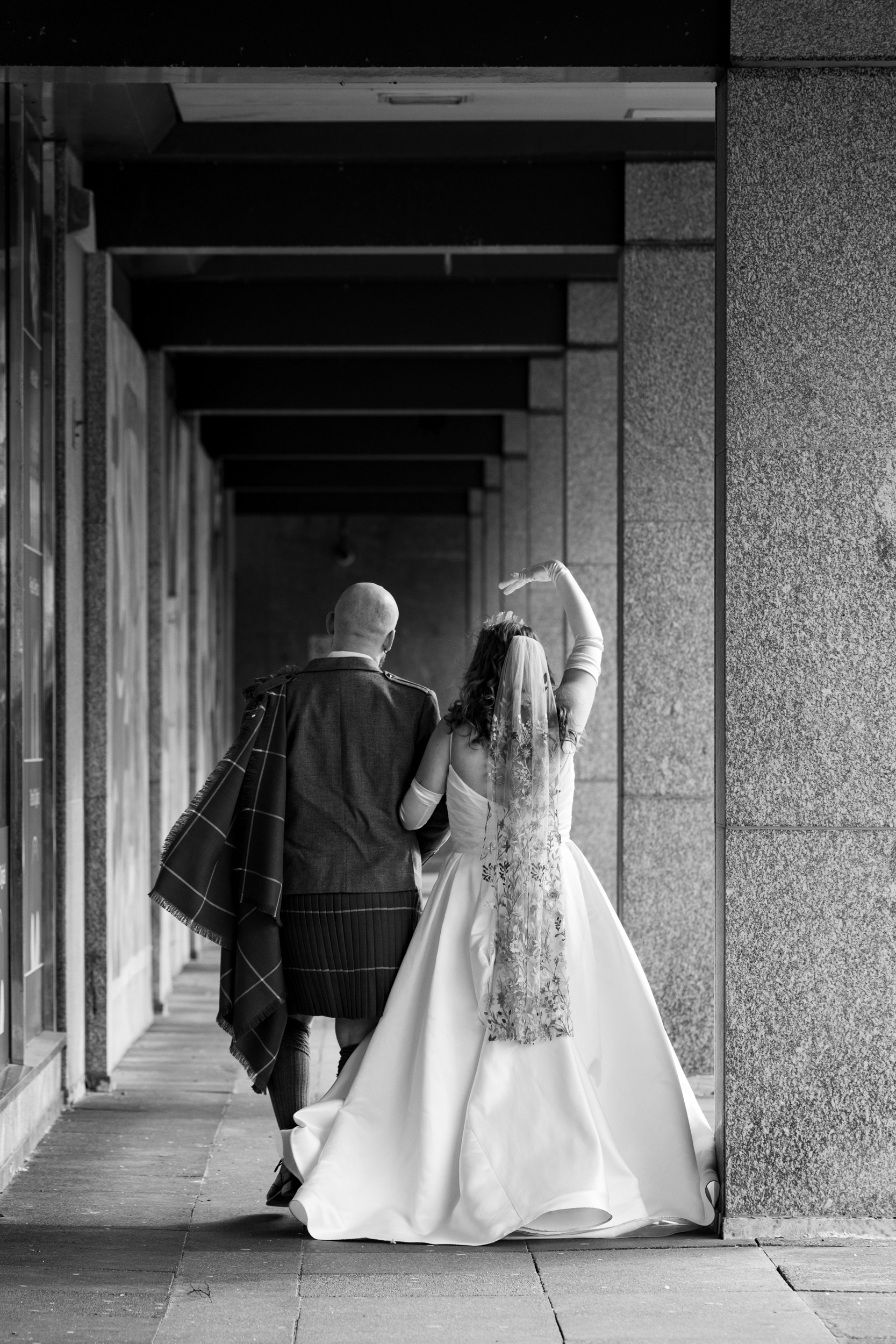 Alternative Aberdeen Wedding Photography: Newlyweds walk arm in arm away from the camera, deep in conversation.