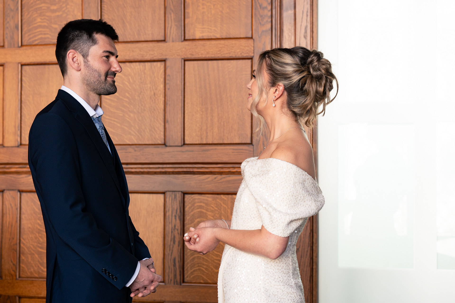 Town hall wedding Aberdeen: stylish bride and groom look into each other's eyes in the Marischal College Grant Room.