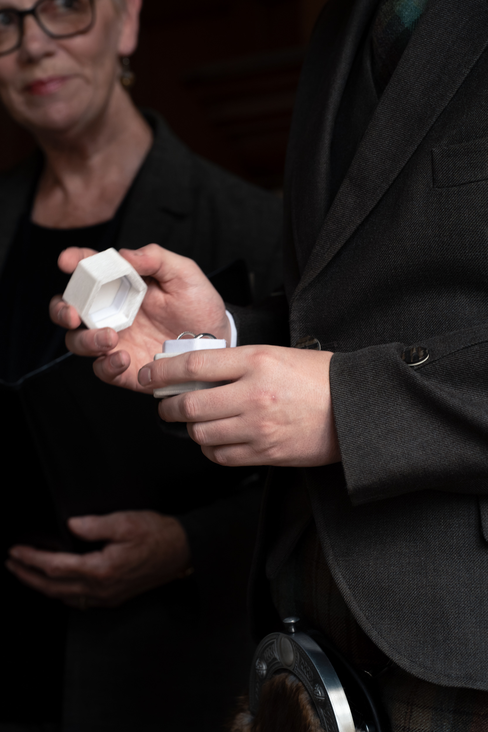 Aberdeen registry office wedding: Close up of hands opening a ring box with two rings inside.