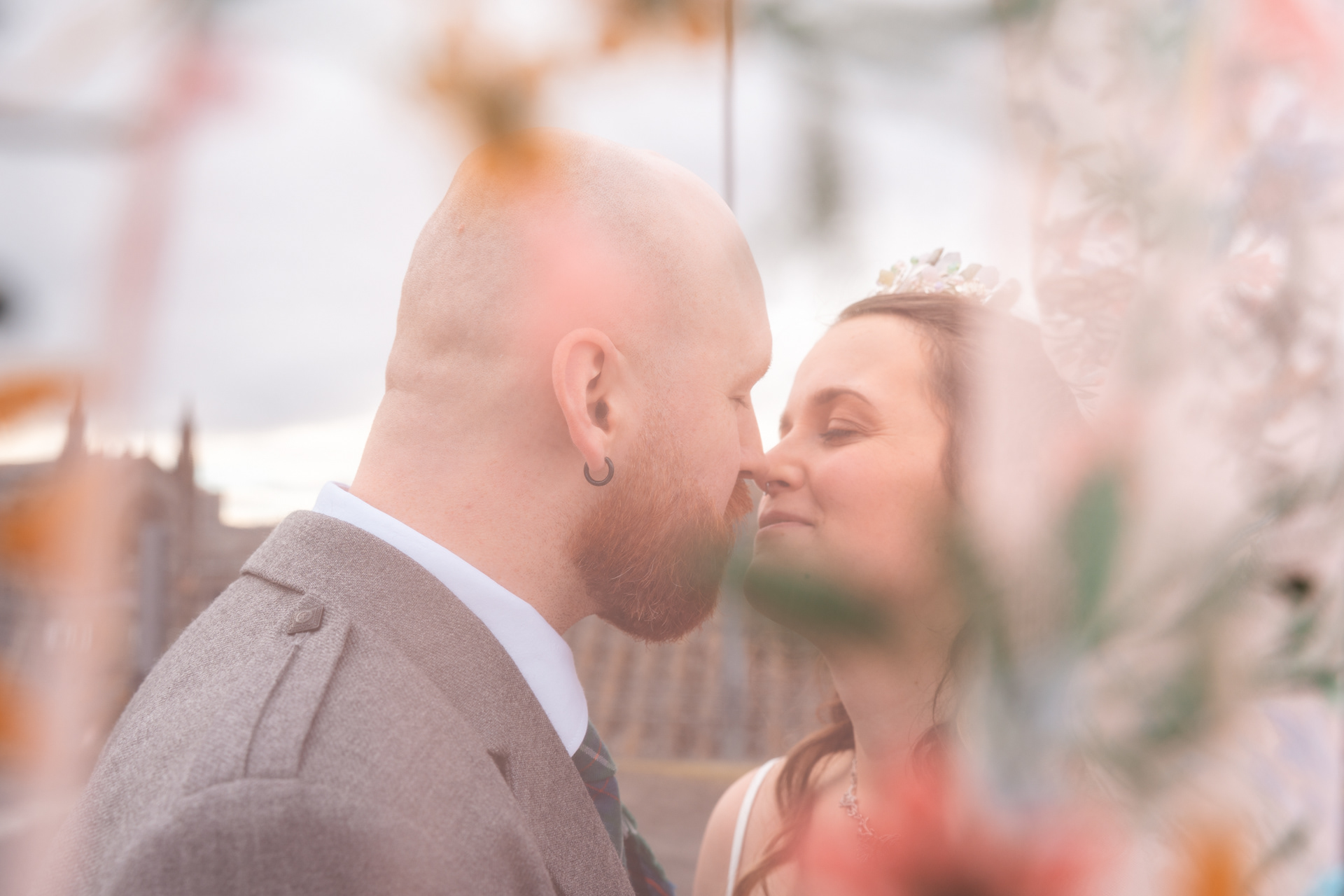Alternative Aberdeen Wedding Photography: Partially obscured by a floral veil, newlyweds lean in for a kiss.