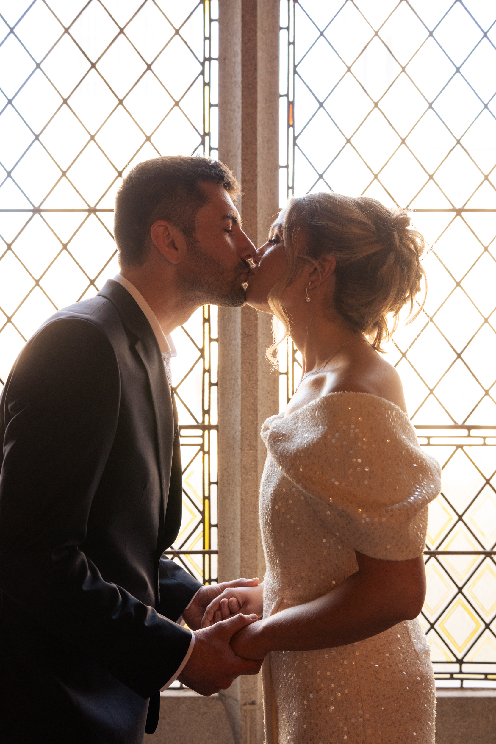 Bride and groom kiss in front of a stained glass window at their Aberdeen registry office wedding.