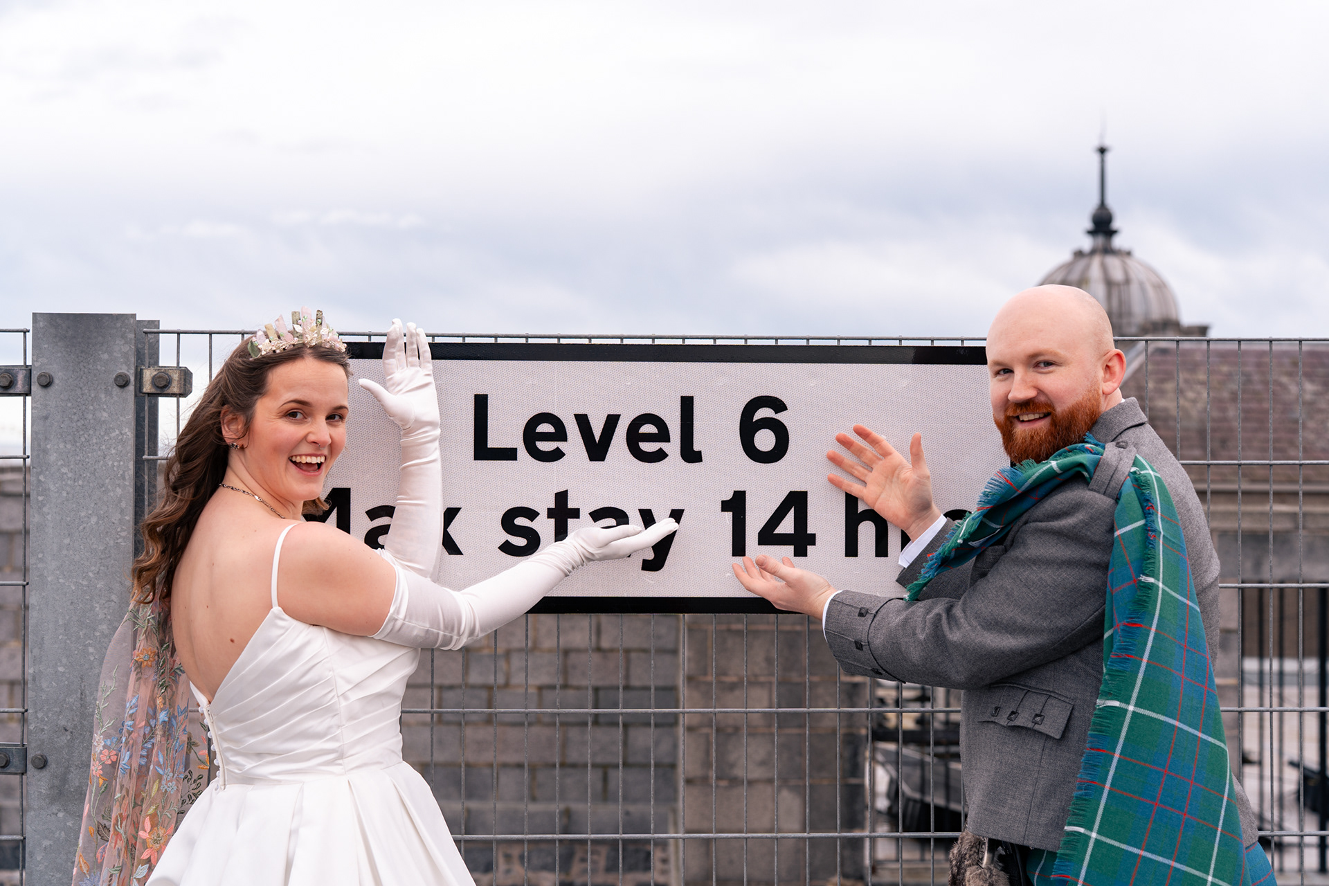 Alternative Aberdeen Wedding Photography: Newlywed couple pose in front of "Level 6" sign.