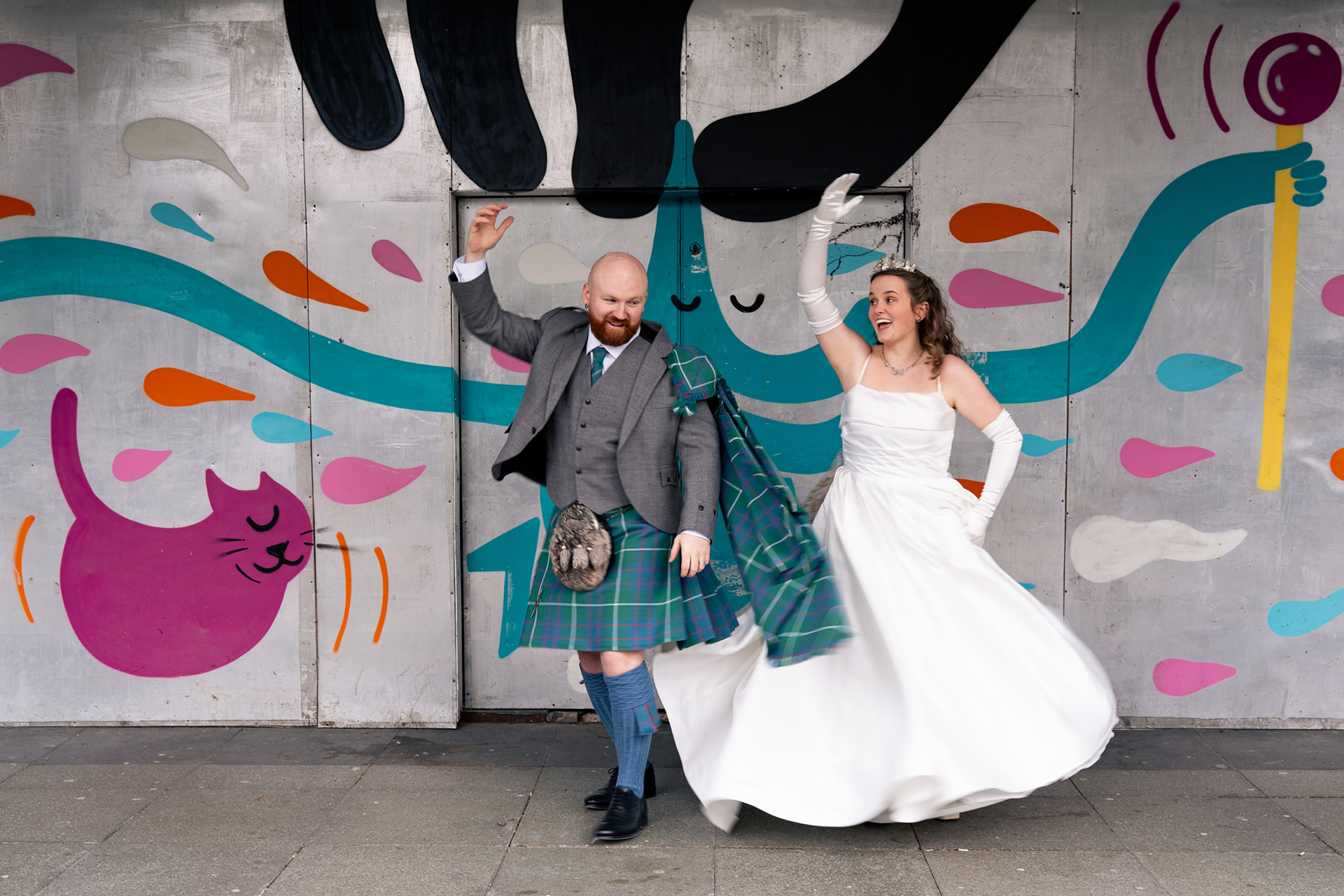 Alternative Aberdeen Wedding Photography: Newlyweds dance in front of graffiti wall.