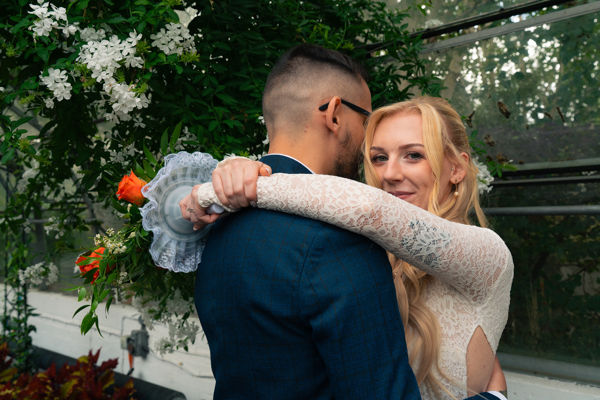 Duthie Park Winter Gardens wedding: Bride and groom hug; she is looking directly at the camera.