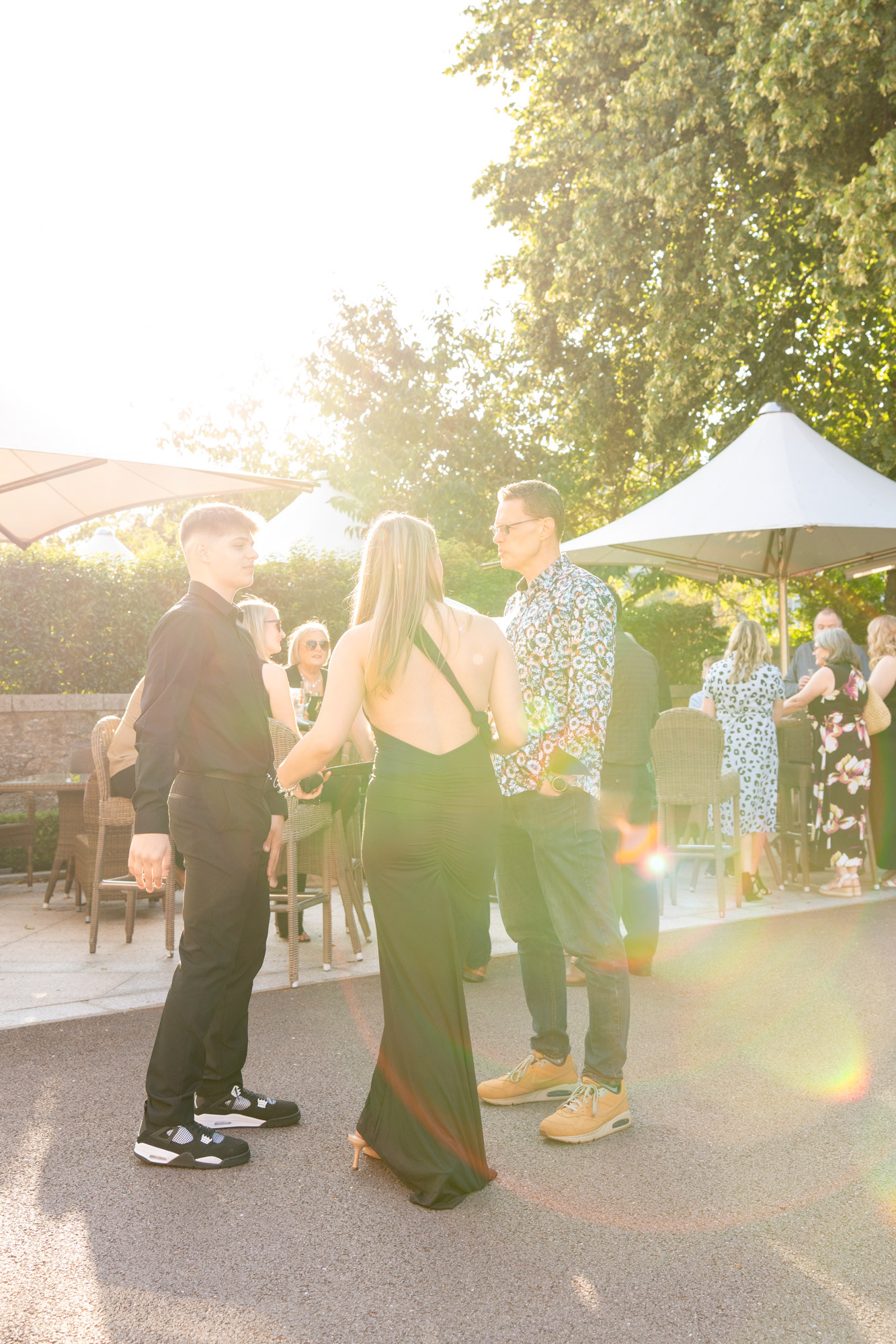Aberdeen party photographer: Sun flare lights up this image of people chatting outside the Chester Hotel at a fiftieth birthday party.