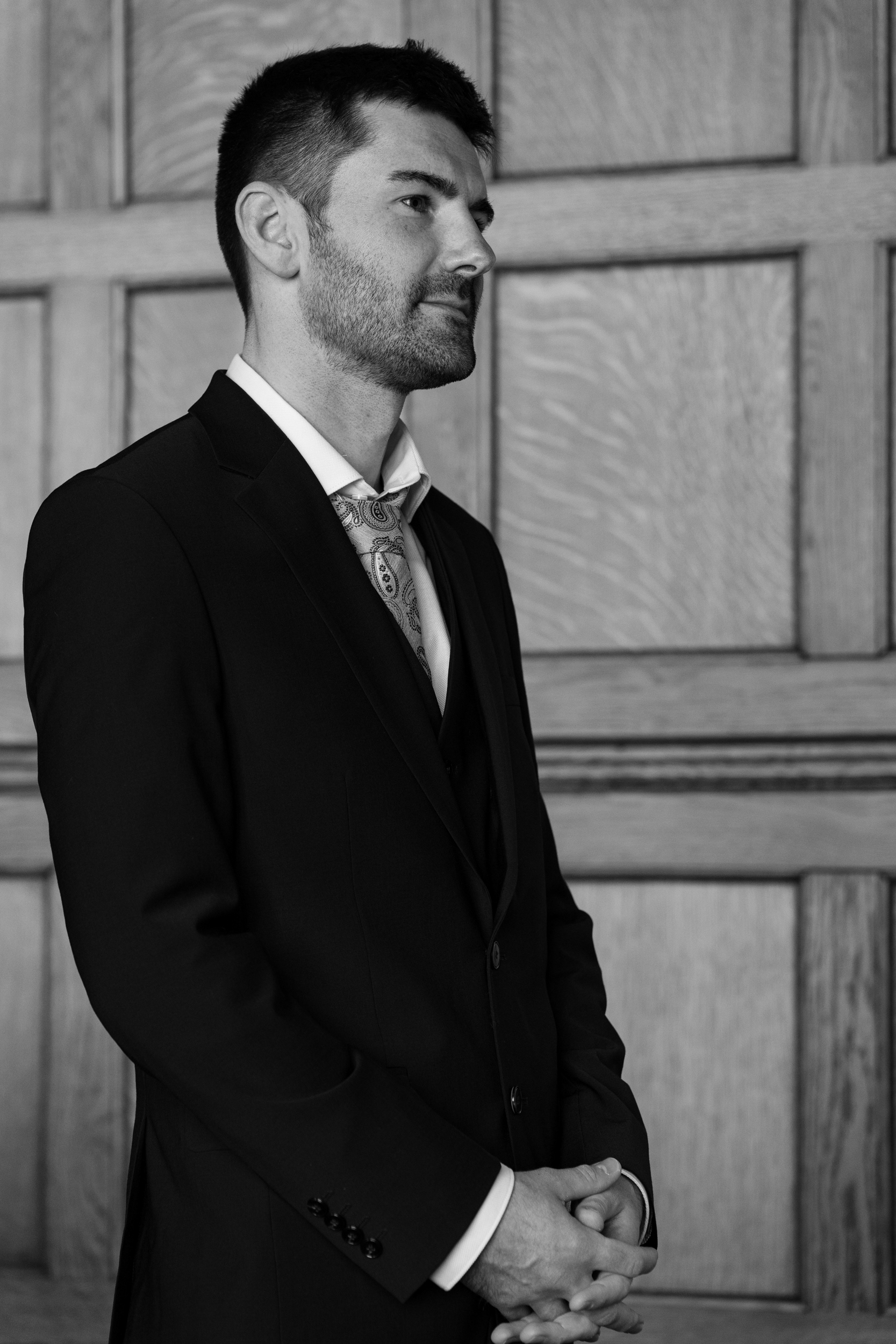 Black and white photo of a groom in a smart suit.