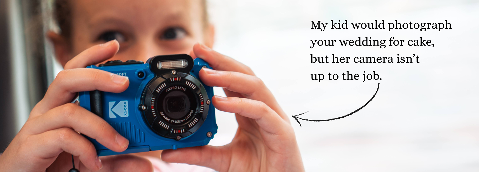 A child's eyes peer above a blue children's camera. The caption reads "My kid would photograph your wedding for cake, but her camera isn't up to the job."