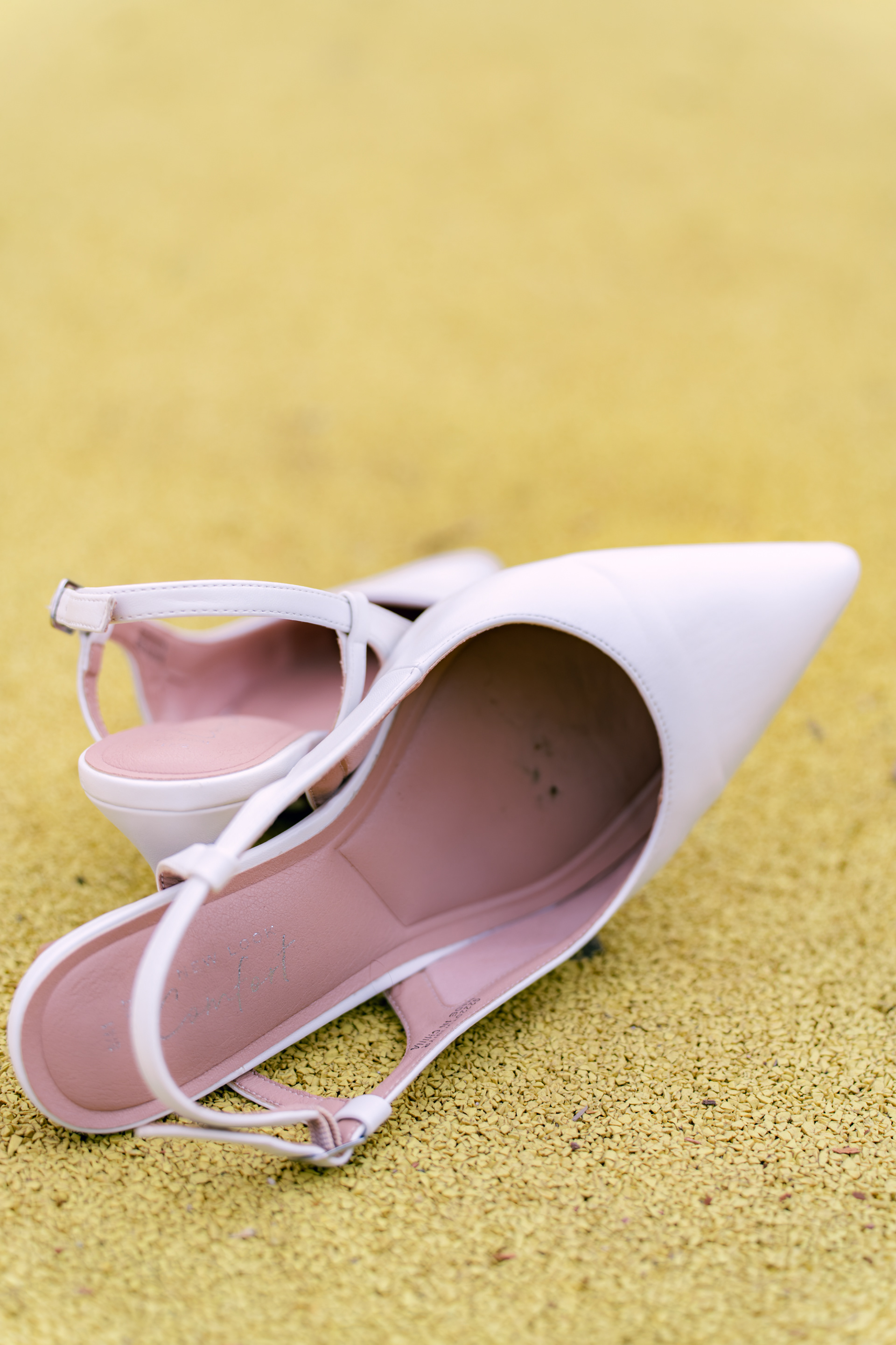 Discarded white high heels lie on the bright yellow surface of an Aberdeen park