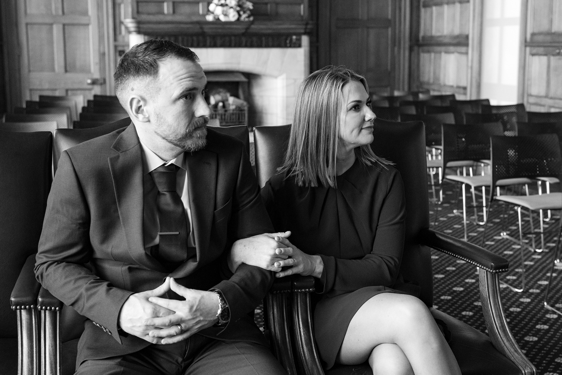Two friends act as witnesses at a Marischal College wedding. They sit, arms linked, watching the ceremony.