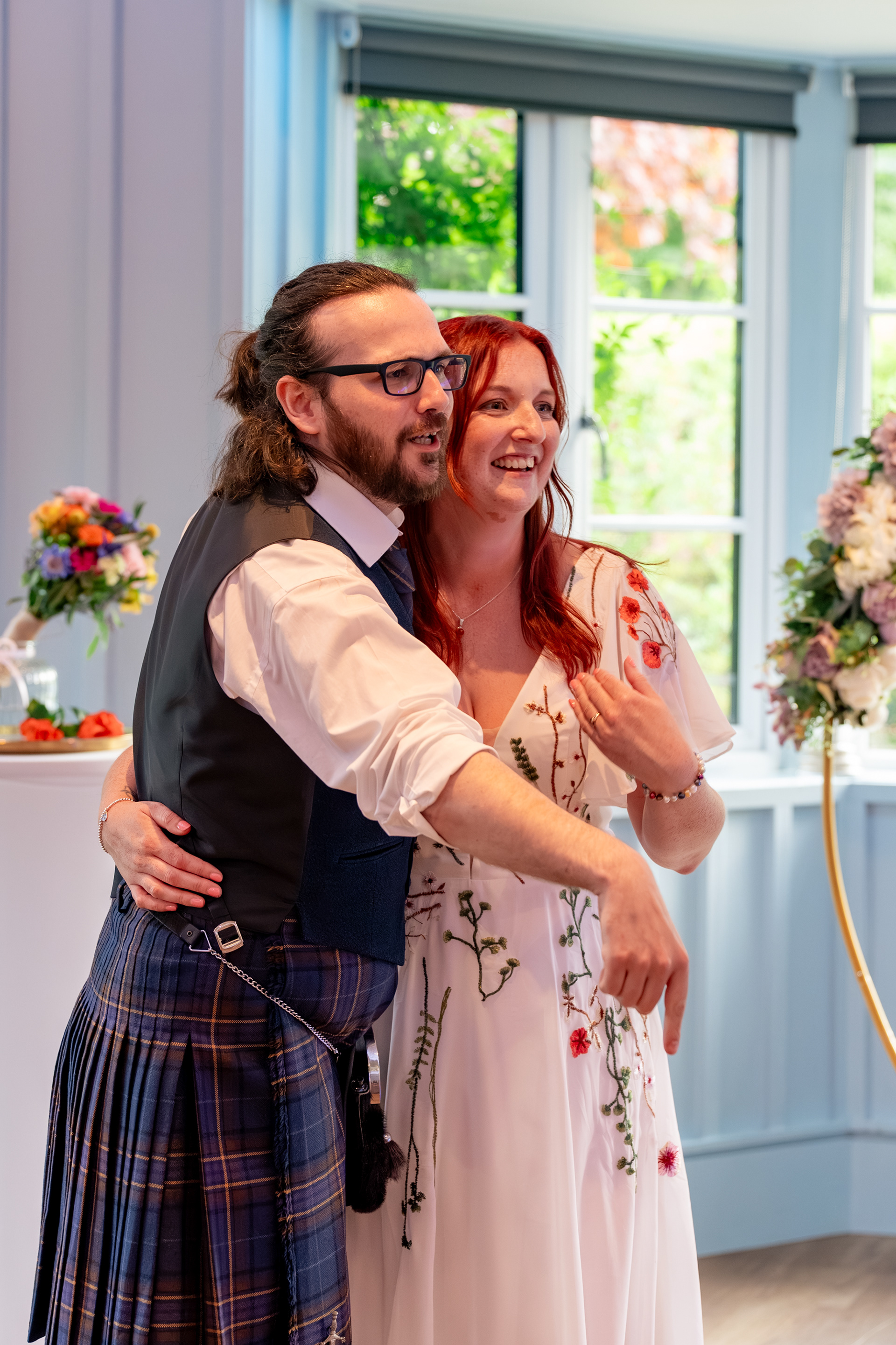 Bride and groom share their first dance during their reception at Hazlehead Park Cafe; they are turning to wave guests onto the dancefloor.