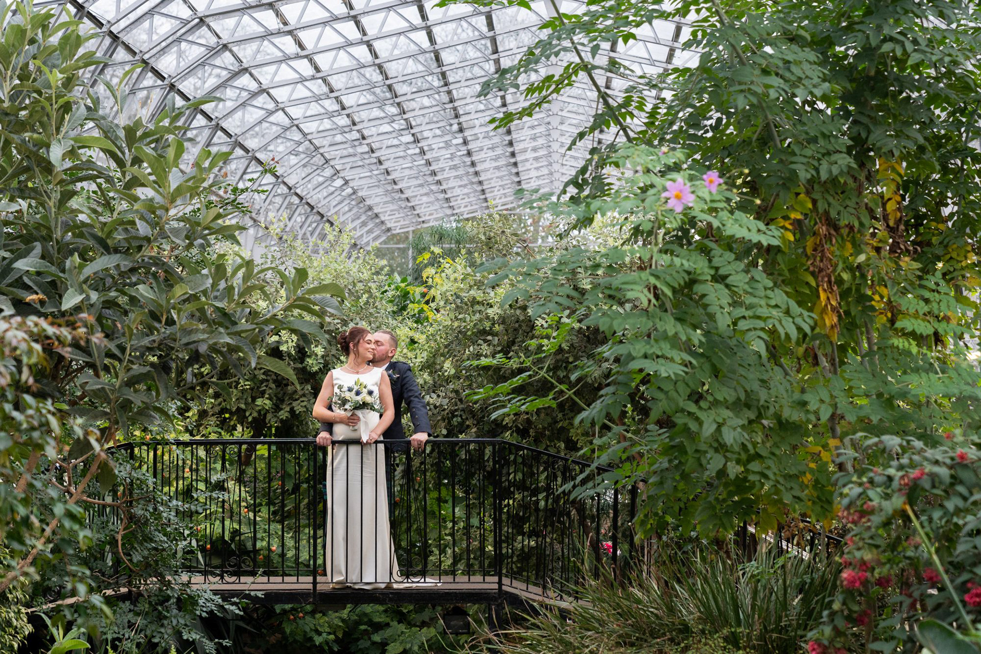 A newlywed couple kiss on the terrapin bridge after their Winter Gardens wedding in Aberdeen.