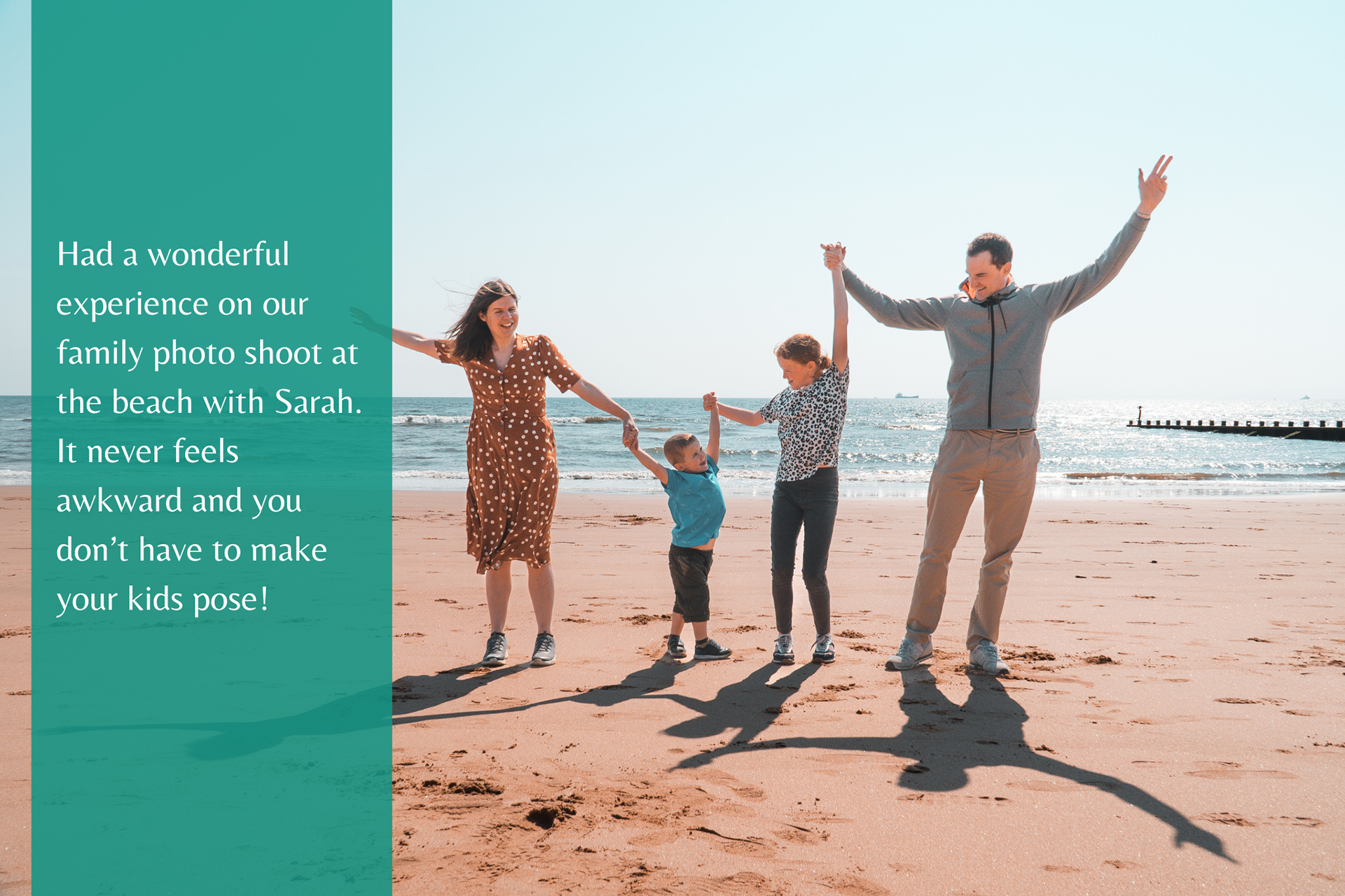 A family of four hold hands and laugh as they raise their arms in the air, during an Aberdeen Beach photo shoot.