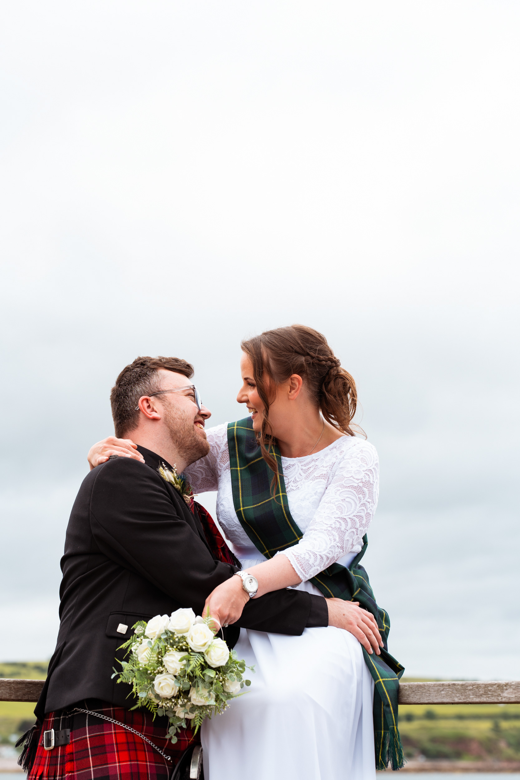 Bride and groom laugh together after their Scottish elopement.