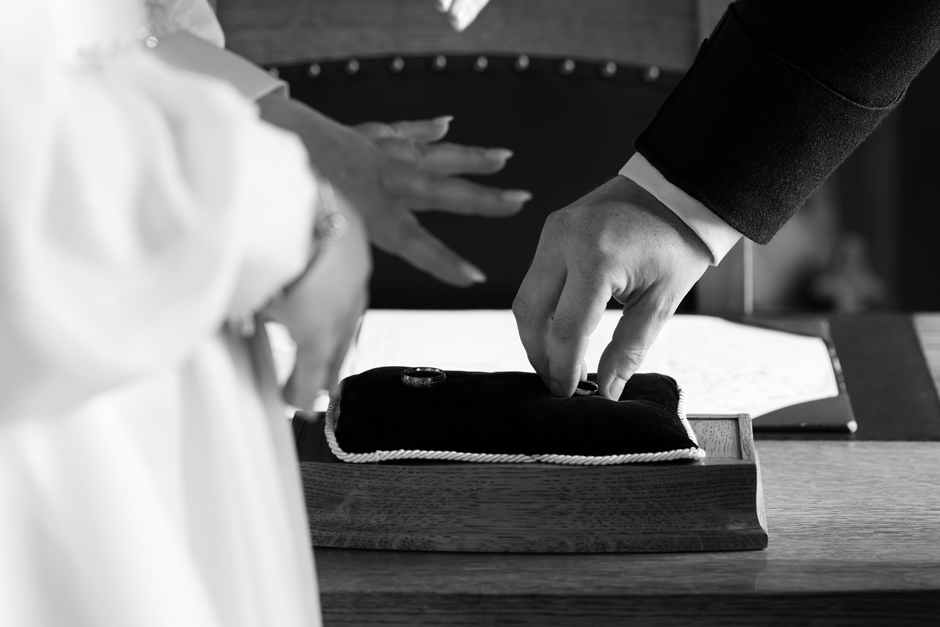 Aberdeen wedding photography: Bride's fingers are outstretched in the foreground as groom's hand reaches for wedding ring.