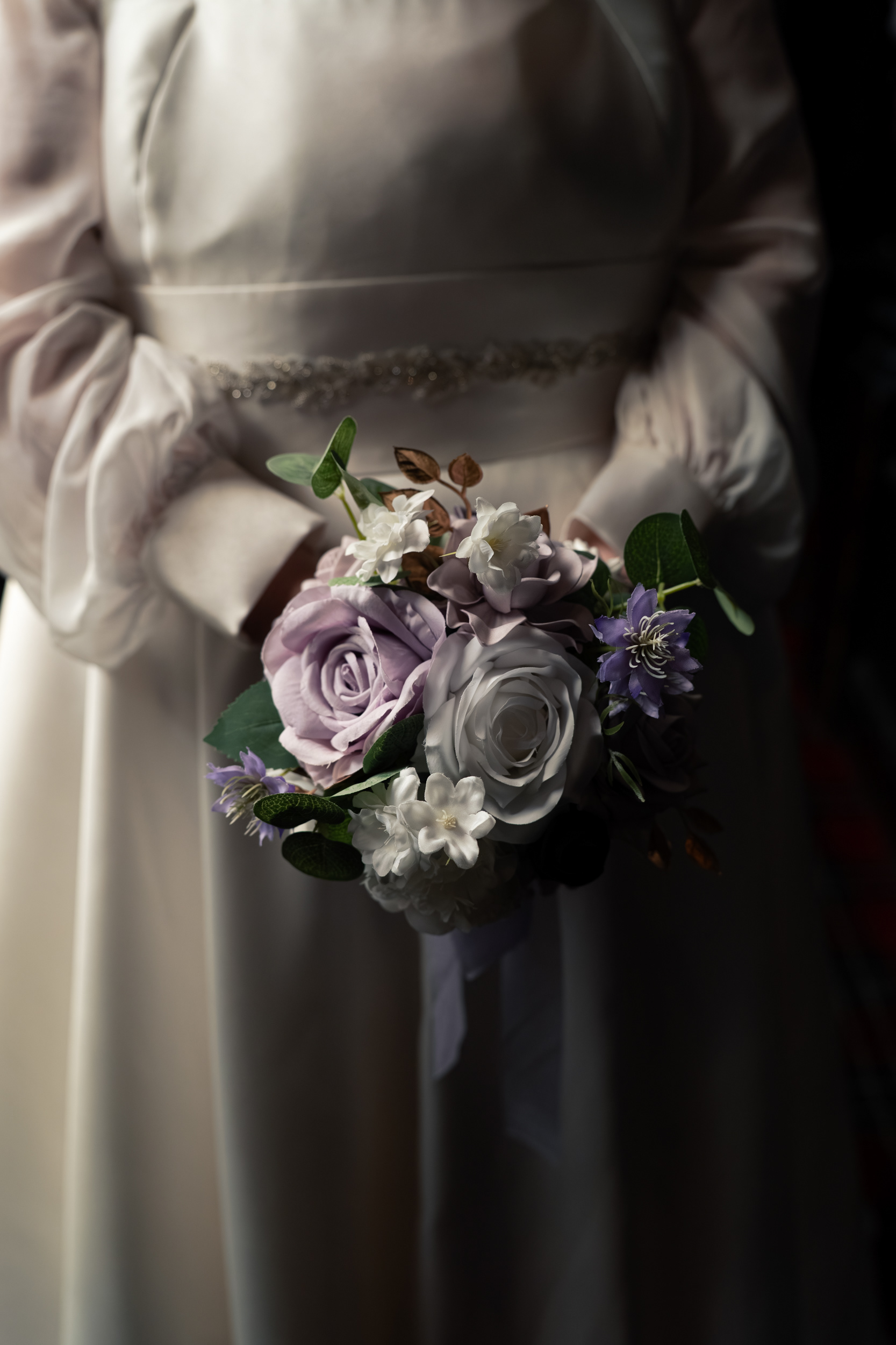 Aberdeen registry office wedding: Detail shot of white and purple bouquet held against bride's vintage-style dress.