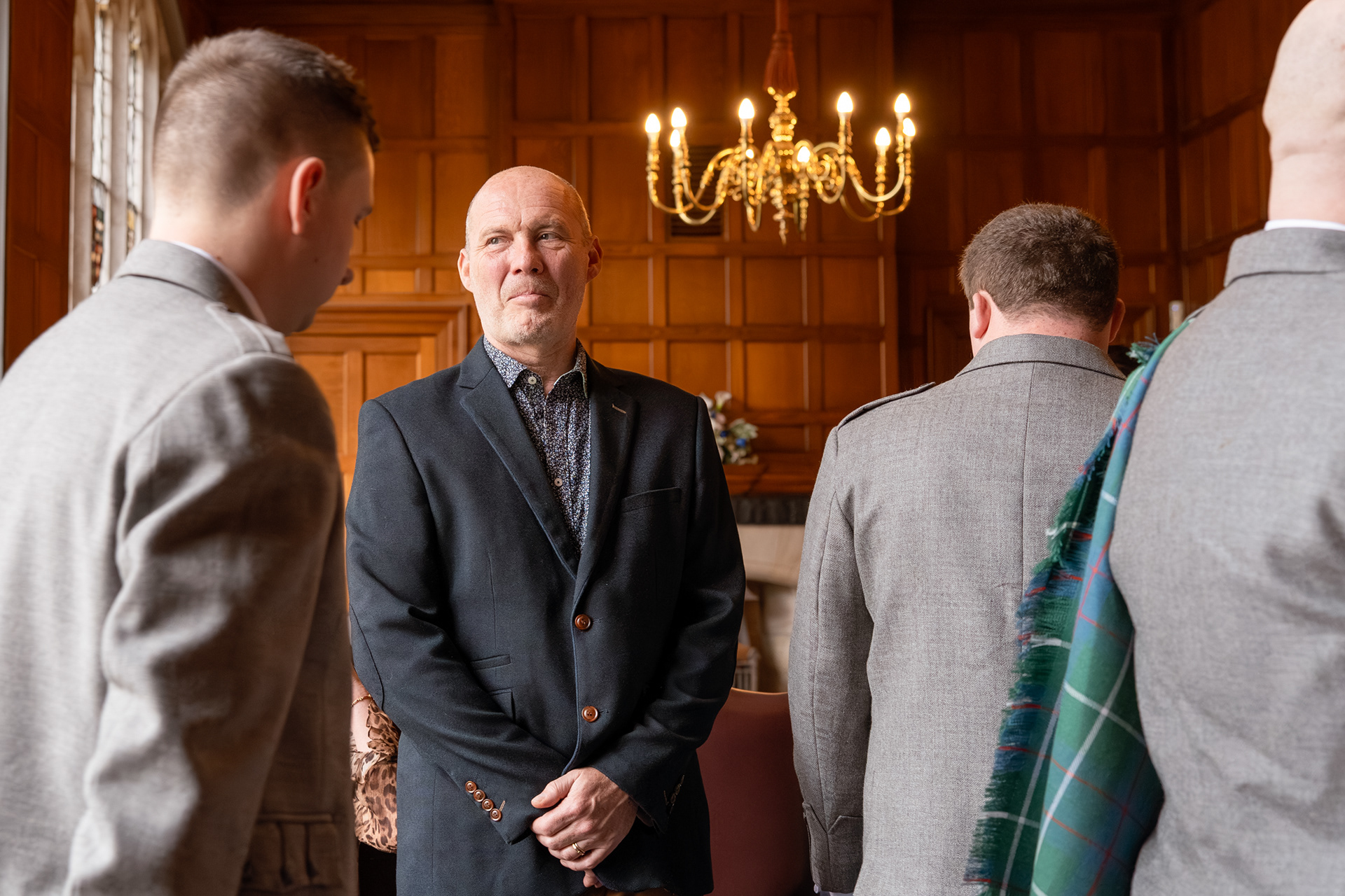 A stepdad looks emotional as the wedding party walks past him at a Marischal College wedding.
