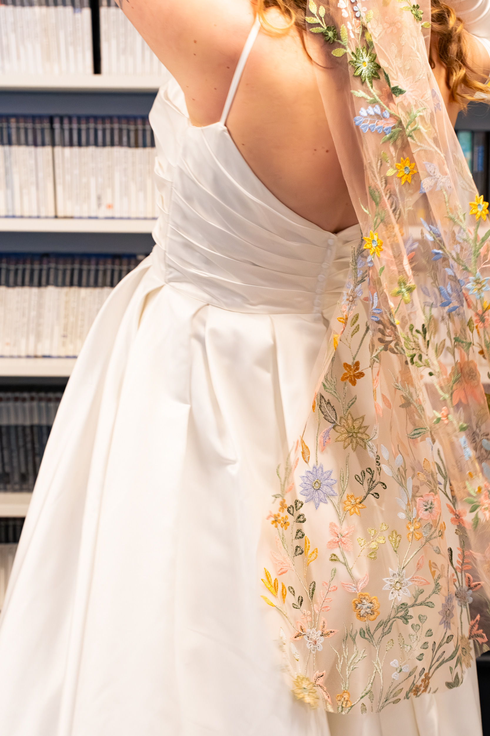 Alternative Aberdeen Wedding Photography: Bride's veil sweeps across the shot; background is video game boxes on shelves.