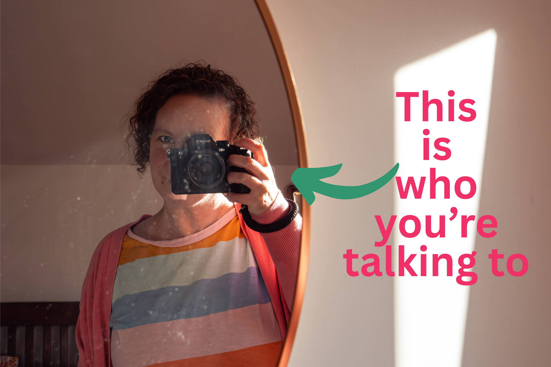 Sarah is taking a selfie in a round mirror. She is white and has short, curly brown hair. She is wearing a pastel striped T-shirt. The overlaid text reads "This is who you're talking to".