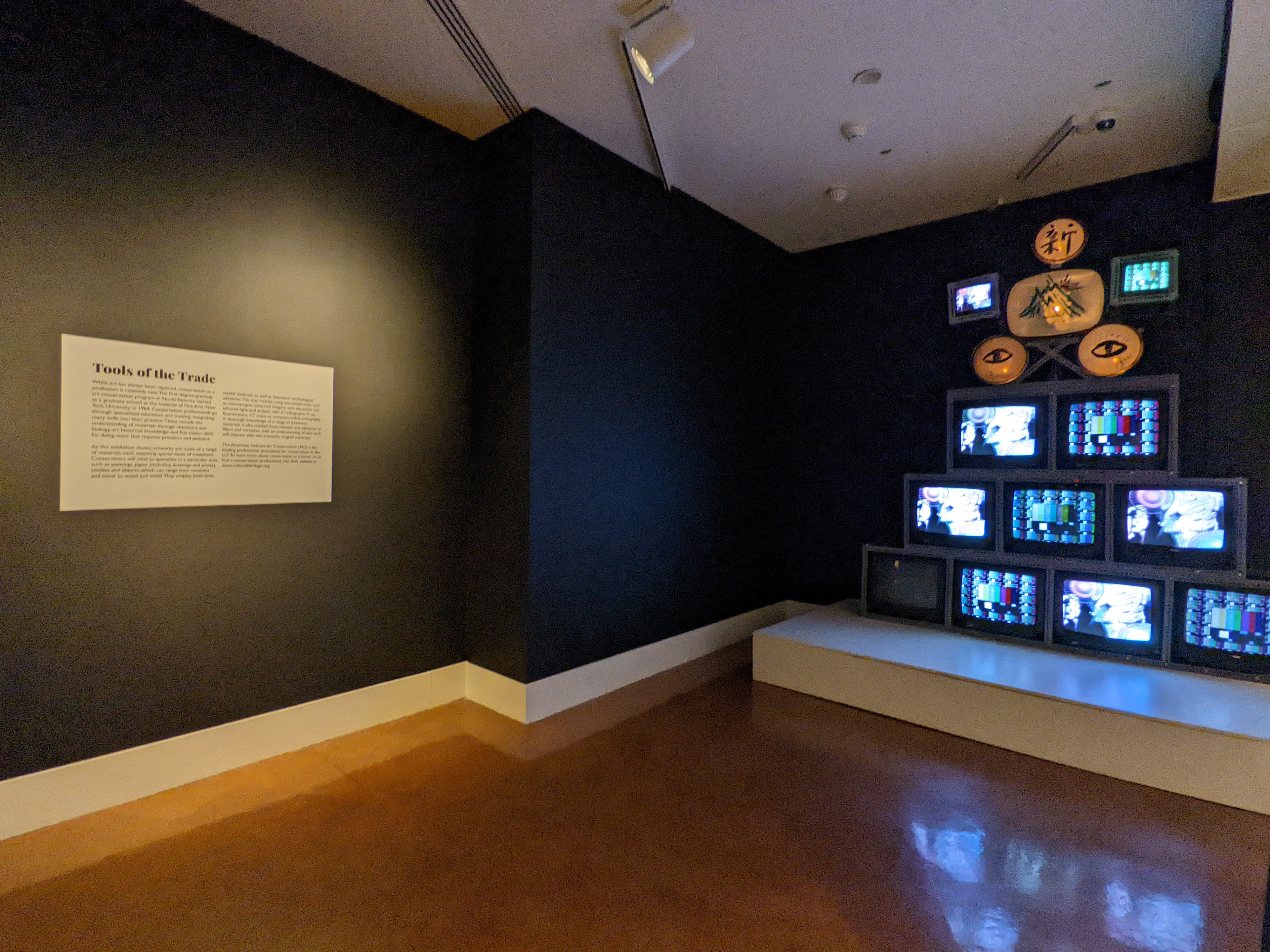 Text panel next to a multi-media art work that was restored to working order.