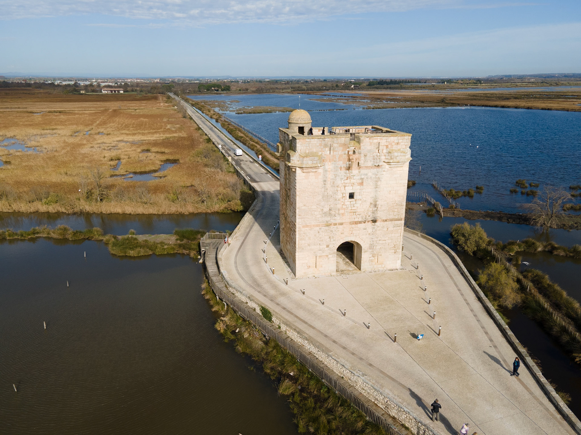 Dressée sur la seule voie terrestre conduisant a la vile d'Aigues-Mortes. la tour Carbonniere a très vite abrité un peage: hommes. animaux etmarchandises qui entraient ou sortaientde la ville devaient s'acquitter d'unetaxe dont étaient exemptés les Aigues-Mortais et les moines de l'abbaye voisinede Psalmodi.
