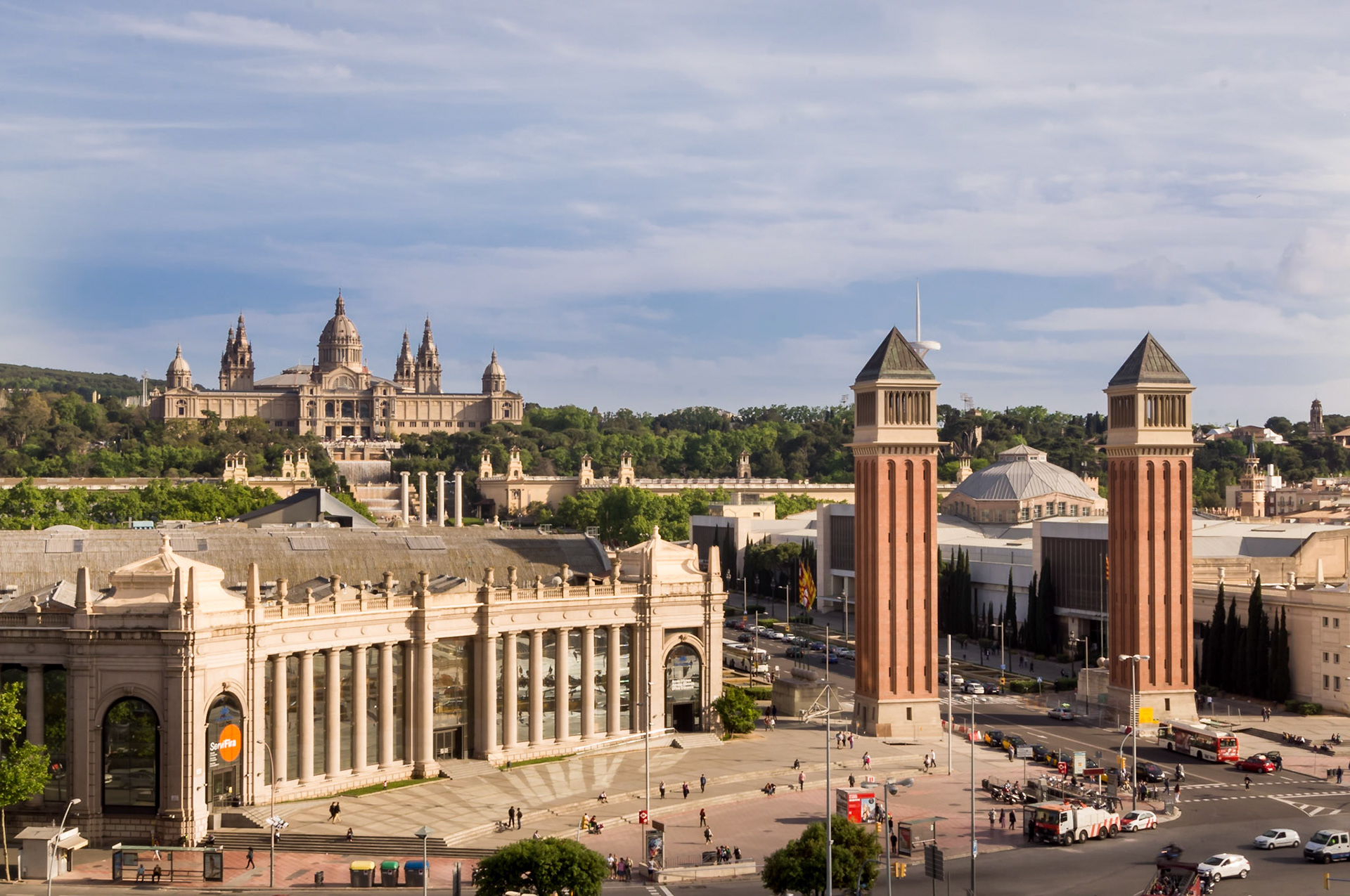 La Plaça d'Espanya et Fira Barcelona. Les deux tours inspirées du campanile de Venise servent d'entrée à l'enceinte du parc des expositions. De là on découvre une perspective sublime sur l'avenue que domine la grande Font Màgica, fontaine lumineuse grandiose et les escaliers majestueux qui conduisent au Musée National d'Art Catalan ( MNAC).