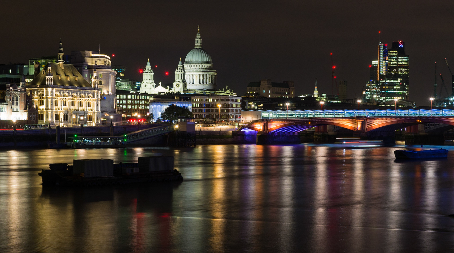 Dans le quartier de la City, la cathédrale St Paul's, chef d'oeuvre de Christopher Wren, se distingue par son dôme et ses deux tours baroques. A droite le Blackfriars bridge présente un éclairage variant de l'orange au violet.