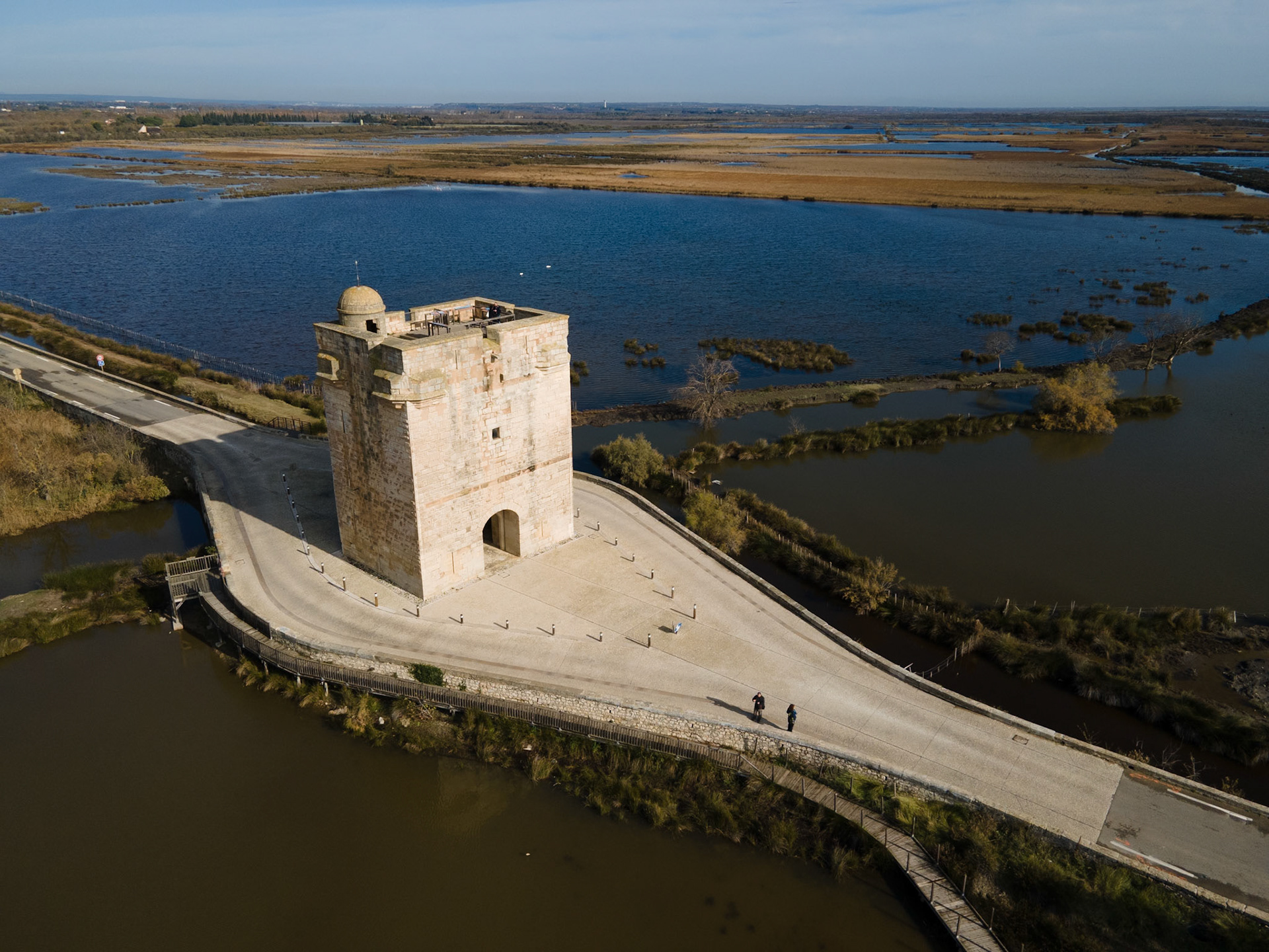 Dressée sur la seule voie terrestre conduisant a la vile d'Aigues-Mortes. la tour Carbonniere a très vite abrité un peage: hommes. animaux etmarchandises qui entraient ou sortaientde la ville devaient s'acquitter d'unetaxe dont étaient exemptés les Aigues-Mortais et les moines de l'abbaye voisinede Psalmodi.