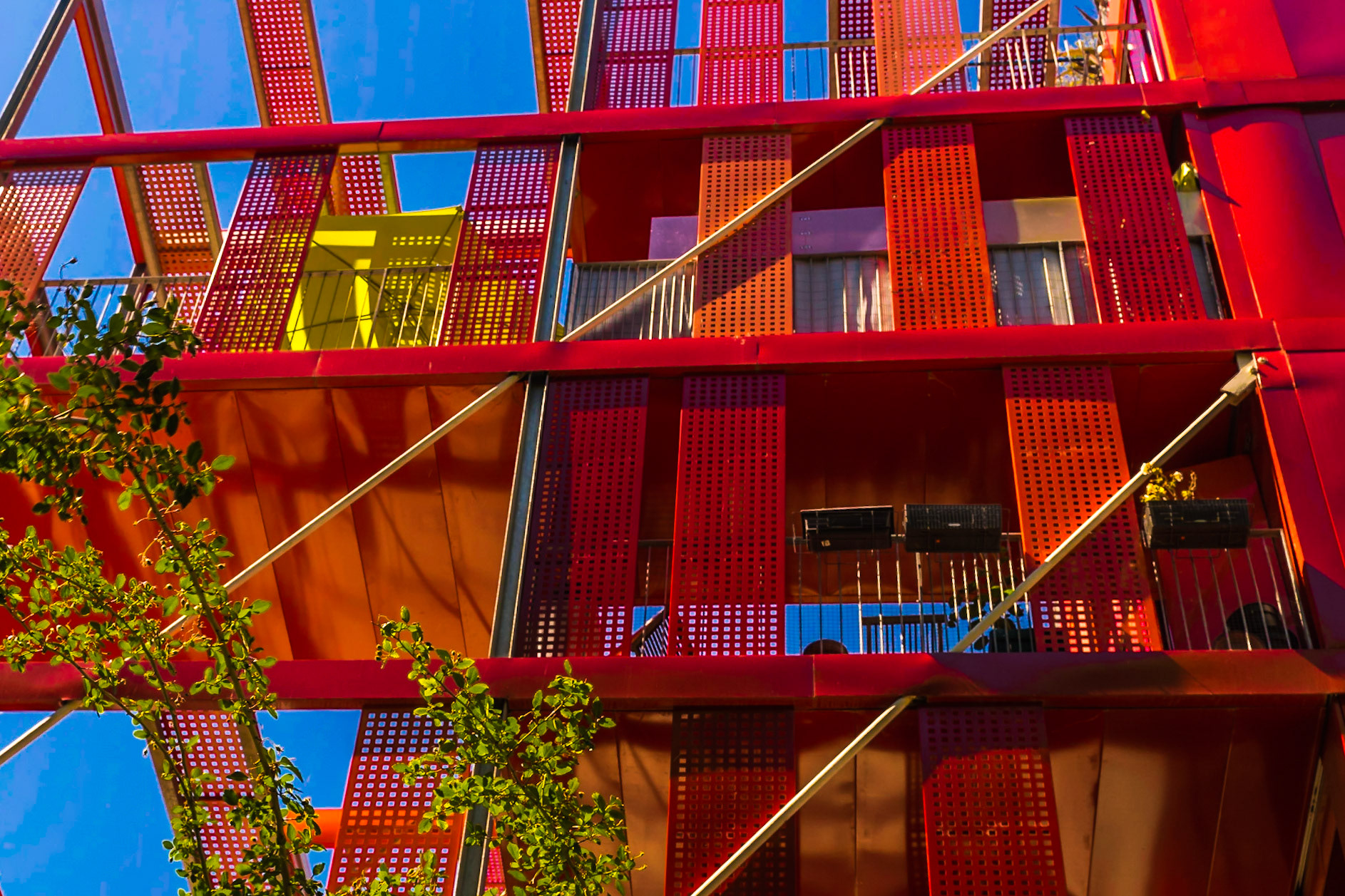 Le bâtiment s’exprime en une variation de quatre types de rouge sur des panneaux en aluminium laqué ou des volets coulissants de même nature. Architecte : Jean-Paul Viguier et Associés