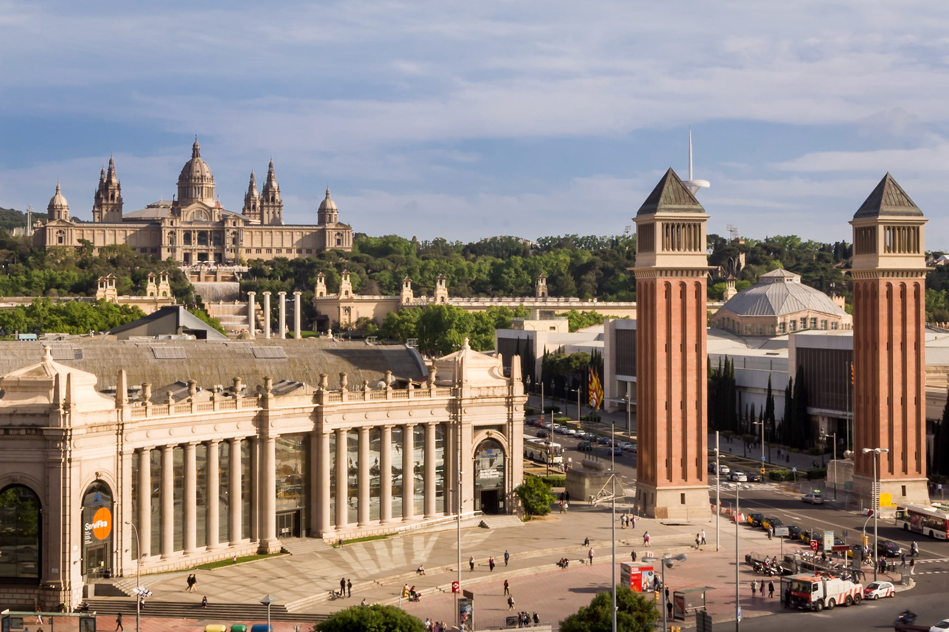 La Plaça d'Espanya et Fira Barcelona. Les deux tours inspirées du campanile de Venise servent d'entrée à l'enceinte du parc des expositions. De là on découvre une perspective sublime sur l'avenue que domine la grande Font Màgica, fontaine lumineuse grandiose et les escaliers majestueux qui conduisent au Musée National d'Art Catalan ( MNAC).