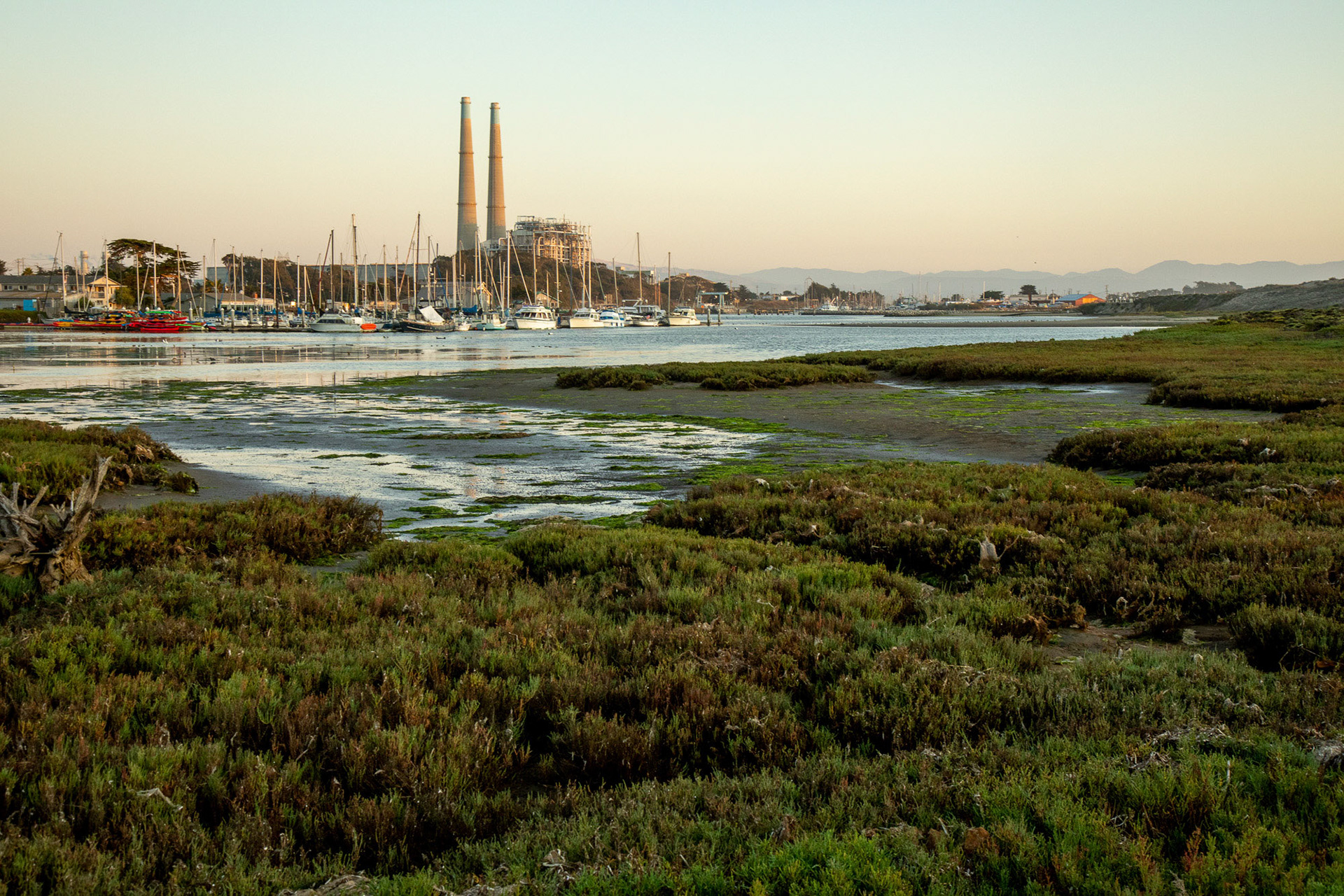 View overlooking the slough, Moss Landing Power Plant and the Harbor from Jetty Road in Moss Landing State Beach. Moss Landing, California, USA, September 19, 2019.  The slough is the United States first estuarine sanctuary and is a RAMSAR wetland.