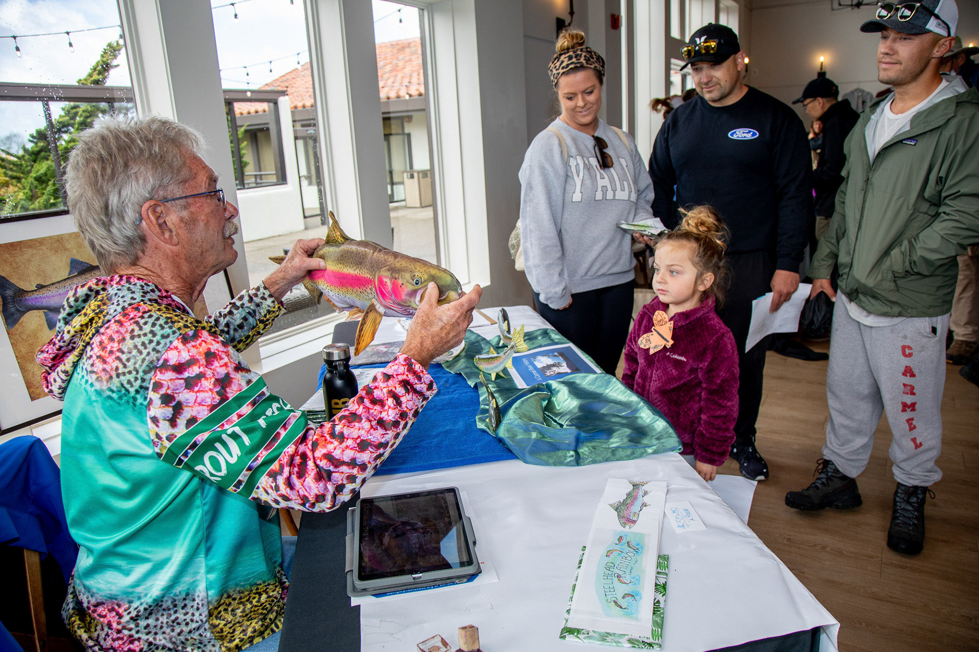 Steve Park, President of the Carmel River Steelhead Association, shows a replica of a steelhead adult to a group of citizens during the 2024 California Wildlife Day in Palo Corona Regional Park, Carmel Valley, California, USA.