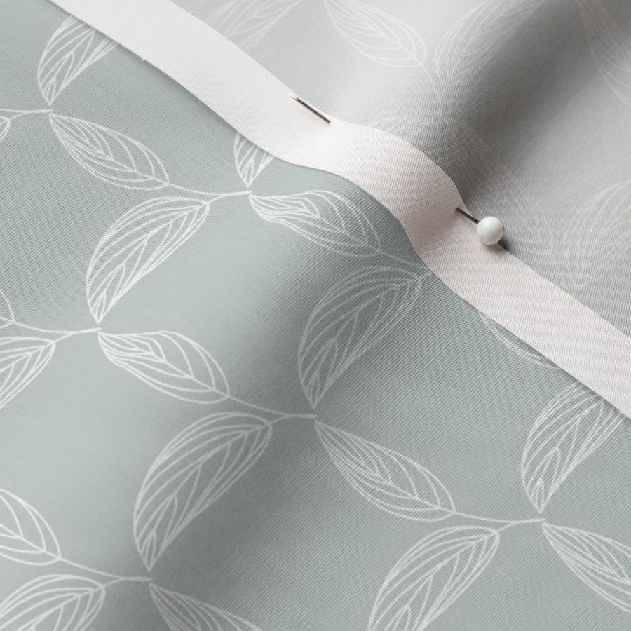 A photo showing the detail of pattern on fabric with a head pin as maker, crafter, seamstress, quilter or home decorator would use to hem the edge in a DIY project. The pattern design reflects the simple, minimalist style of the artist with botanical motif in hand drawn line art. This repeat pattern showcases the artwork available for licensing or on products to purchase designed by Stephanie Fielden.