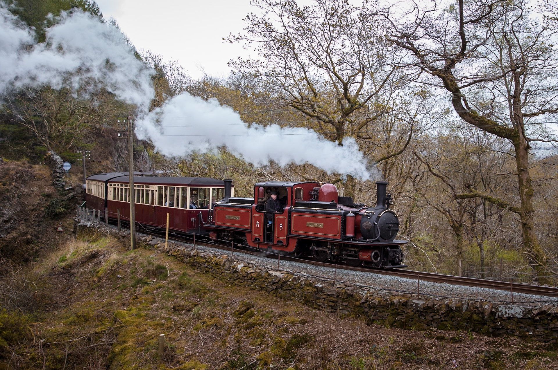 The development of steam locomotives has seen many strange designs put into service, with the double-Fairlie being one such design. Built to Fairlie's Patent, the locomotive superstructure rests on two articulating power units housing the wheels, cylinders, and drawgear. This design allows large locomotives to navigate the sharp curves typical of most narrow gauge railways. This example, "David Lloyd George" (or "Dafydd Lloyd George" in Welsh) was built brand new in 1992 at the Ffestiniog Railway's workshops at Boston Lodge. Thanks to the way the Ffestiniog Railway was preserved - it is now the worlds oldest surviving railway company, and one of few remaining companies brought into existance by acts of parliament - David Lloyd George can rightfully be considered the sixth double Fairlie class member, and not a replica.