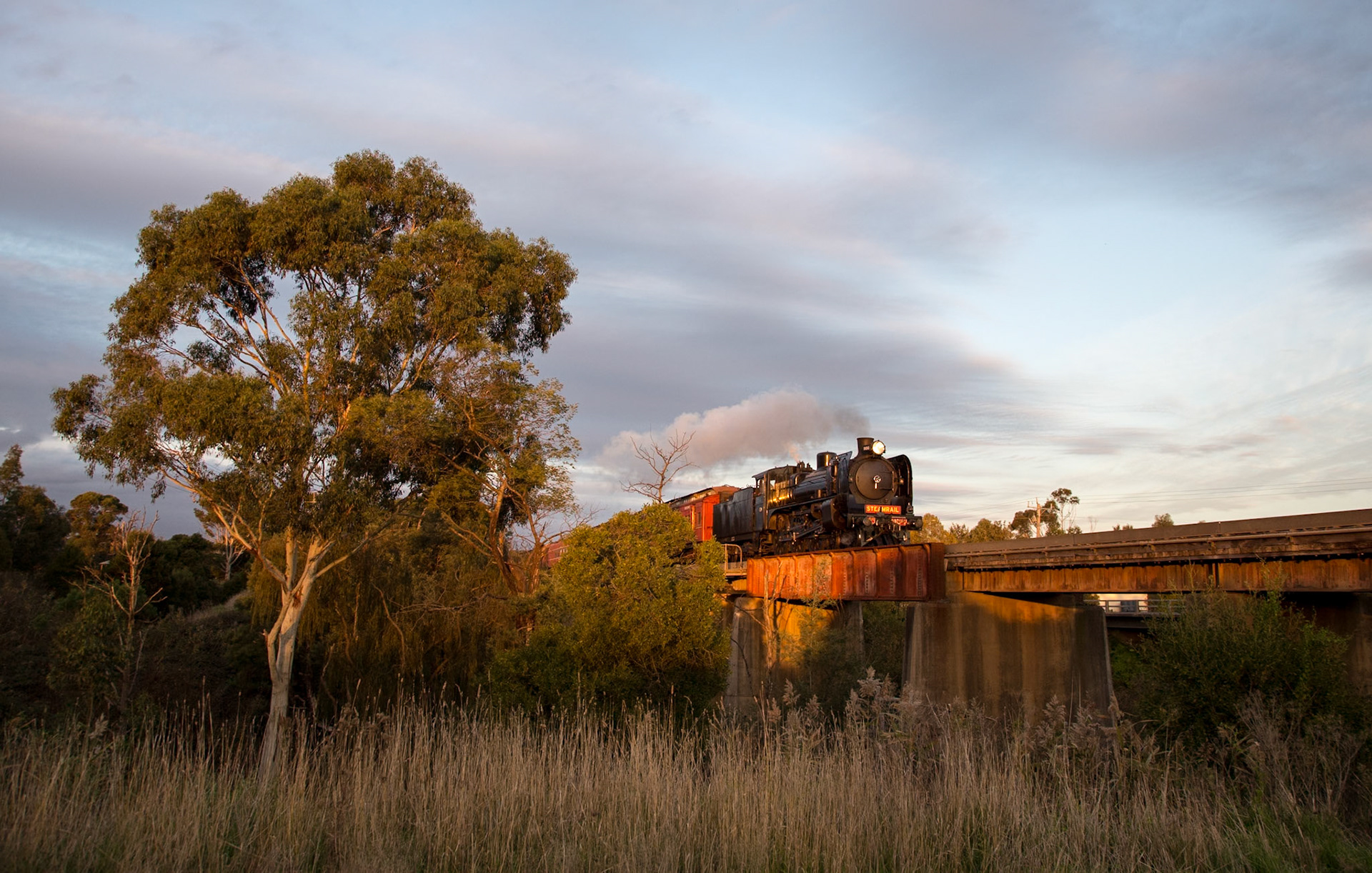 Returning from Traralgon after a successful relauch trip, A2 986 storms across the Bunyip River bridge between Longwarry and Bunyip and catches the last rays of sunlight.