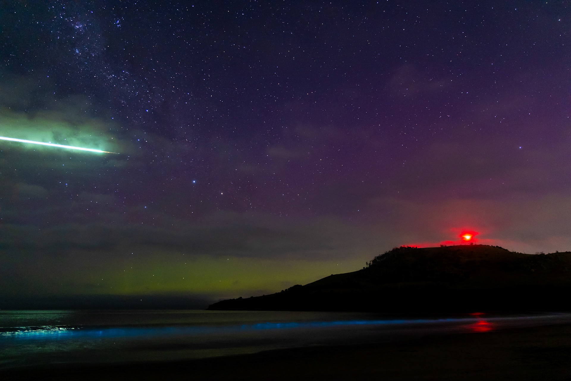A Boxing Day treat! Strong solar weather on Boxing Day 2022 generated a strong Aurora Australis, visible as far north as the Murray River. Down in Tasmania however, we got an extra treat: space junk burning up on re-entry over a strong bioluminescence event. Captured at Seven Mile Beach, the red beacon on the hill is a marker for Hobart Airport, out of frame behind me.