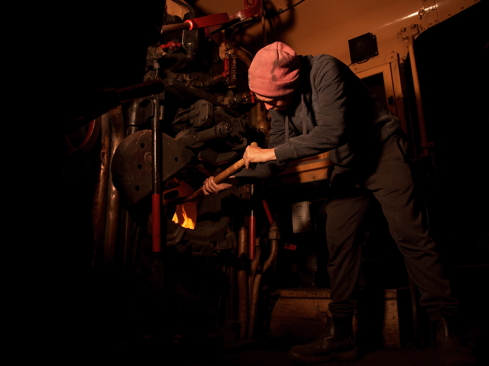 Before resting up for the night, one of Steamrail's volunteers tops up the fire of K183 during the 2022 Newport Workshops Open Days event.