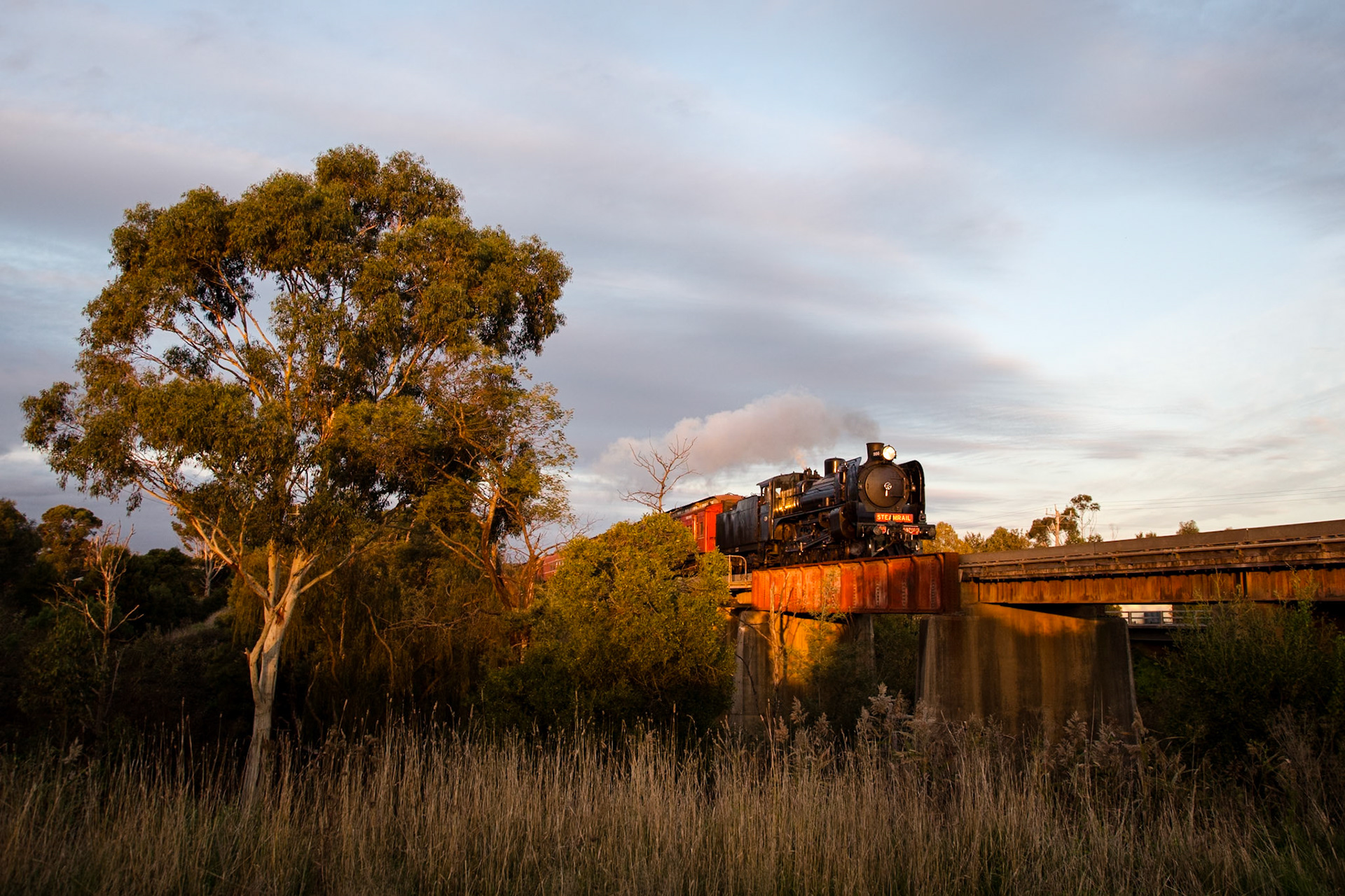 Returning from Traralgon after a successful relauch trip, A2 986 storms across the Bunyip River bridge between Longwarry and Bunyip and catches the last rays of sunlight.