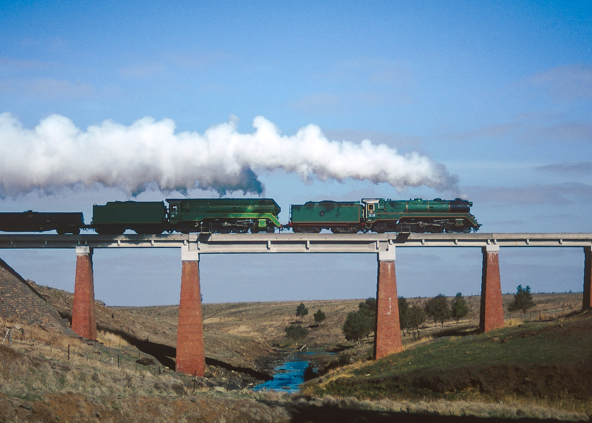 During a photo stop on their way to Ararat, 3830 and 3801 tear across the bridge over Mount Emu Creek under perfect lighting. Stretching for over 250km Mount Emu Creek is Victoria's longest creek, starting near Trawalla and emptying out to sea via the Hopkins River.