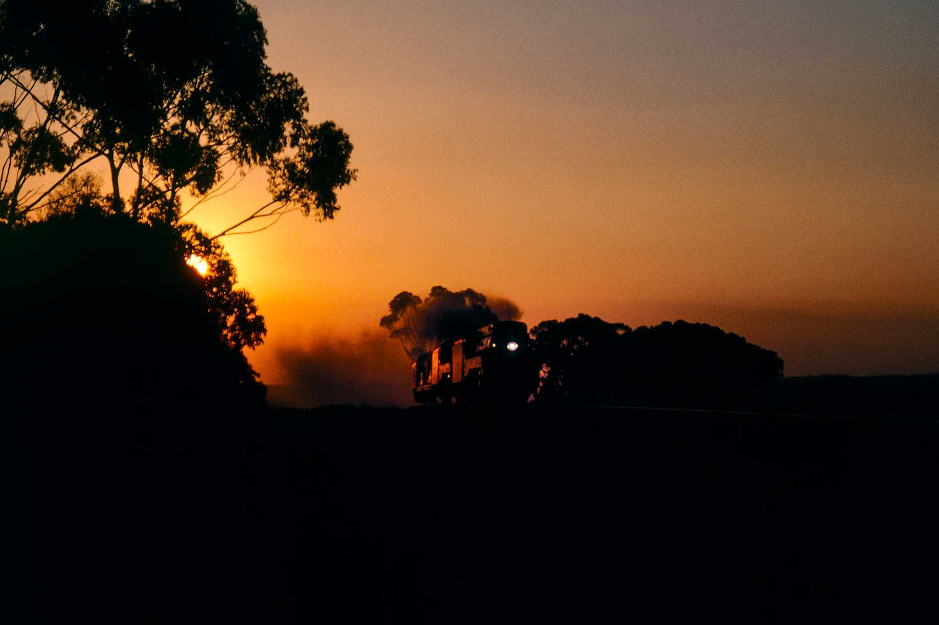 The setting sun marks the end of steam in western Victoria as 3801 and 3830 make a spirited run through Berrybank back to Melbourne, hauling only their water gins and support vehicle.What should have been a daylight run east with the silver Southern Aurora carriage set in tow was turned into disarray when G519 derailed at Dimboola in the early hours of the morning, blocking the 38s in at the turntable. While the 38s waited for the G to be rerailed and moved out of the way, the remainder of the train was hauled back to Melbourne by 4201 and 44211.Faced with the choice of following diesels back to Melbourne or waiting around for the 38s, we opted to wait: while the delay cost us potential photos as the light faded, it was balanced out by the knowledge we were unlikely to see steam in this part of the country for a while.
