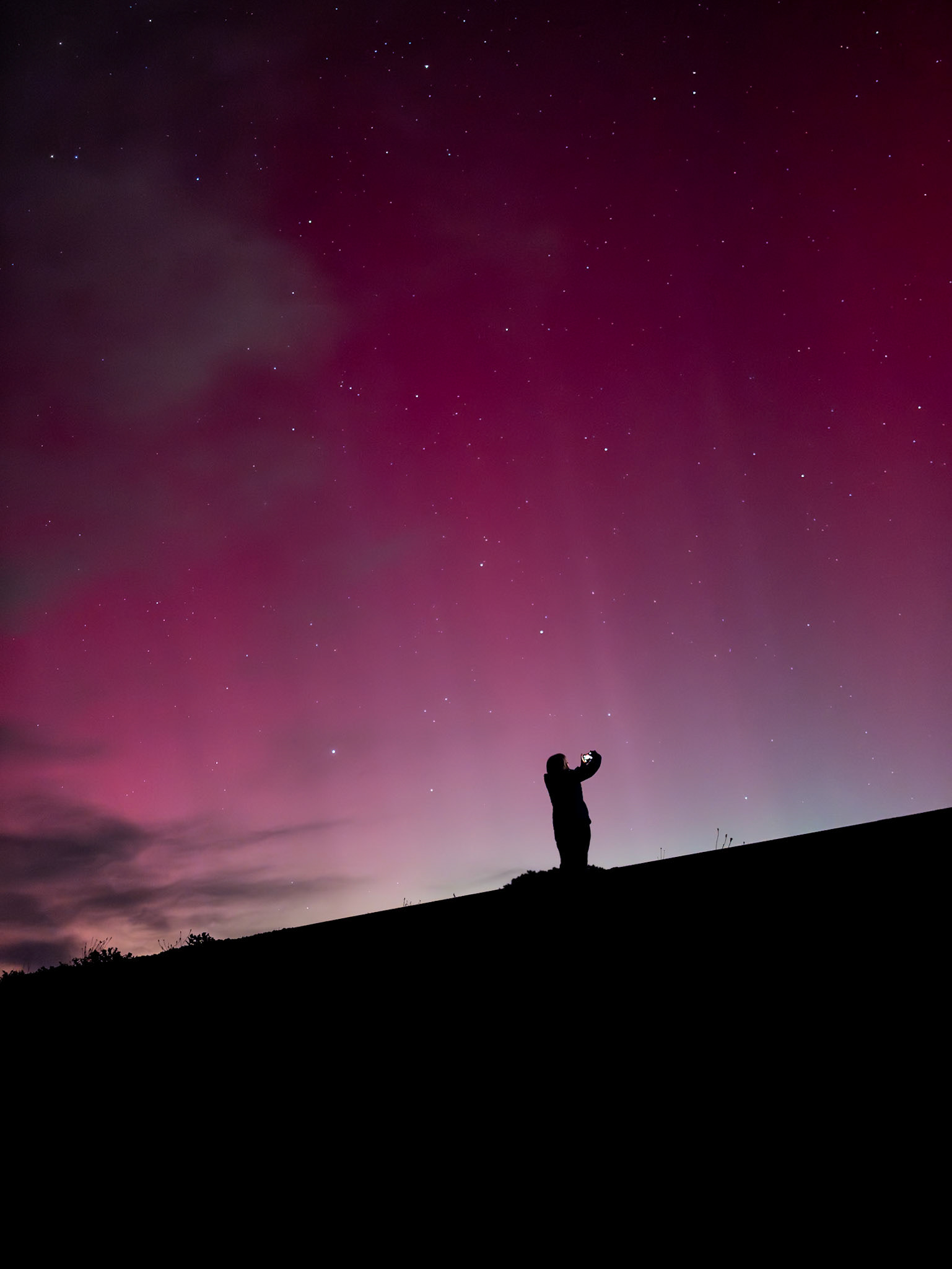 Standing on the railway embankment near the Gembrook football ground, one of the locals is silhouetted against the aurora-filled sky.