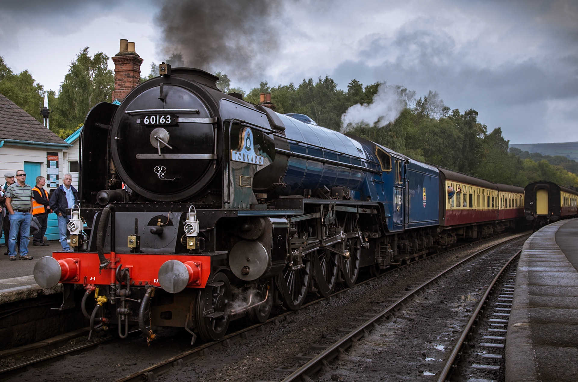 Newly-built A1 no. 60163 "Tornado" stands in platform 1 at Grosmont station as passengers board for Pickering.With construction commencing in 1994, "Tornado" is the first mainline steam locomotive to be built in the UK since 1960 and was launched into service in 2008. The locomotive is almost identical to other class members built, with only minor alterations made to accommodate cost, safety and operational requirements. This was taken on day one of the North Yorkshire Moors Railway's LNER Weekend in early October 2013.