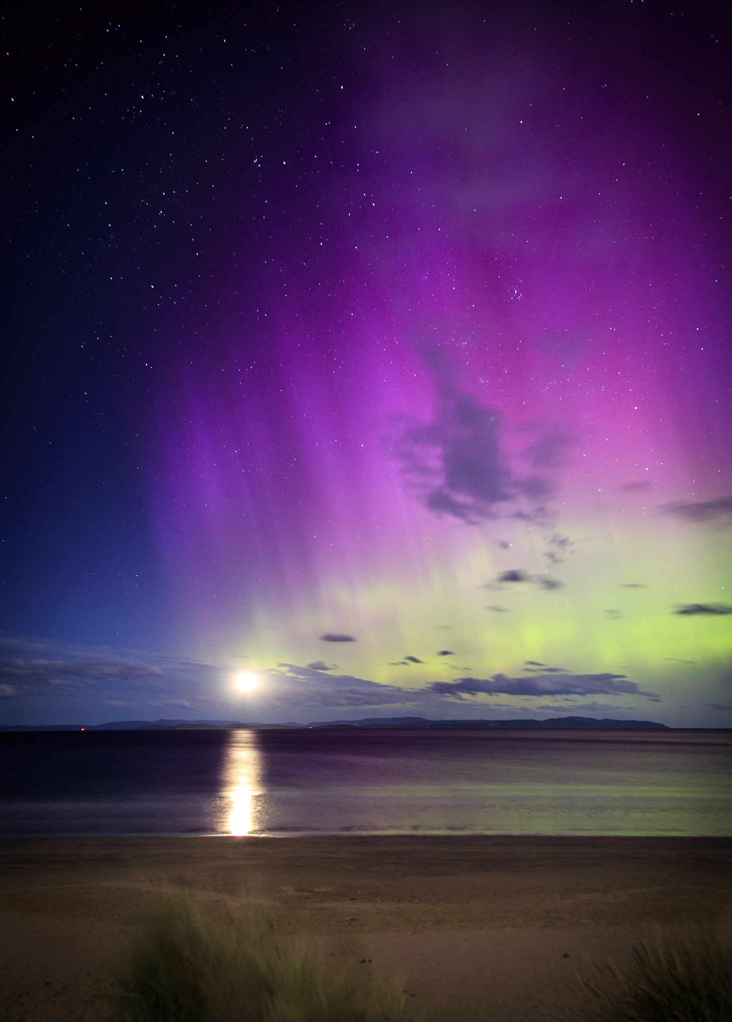 As an aircraft approaches Hobart International Airport one of the year's most intense auroral displays paints the sky green and pink, the effects so strong they could be seen with the naked eye.