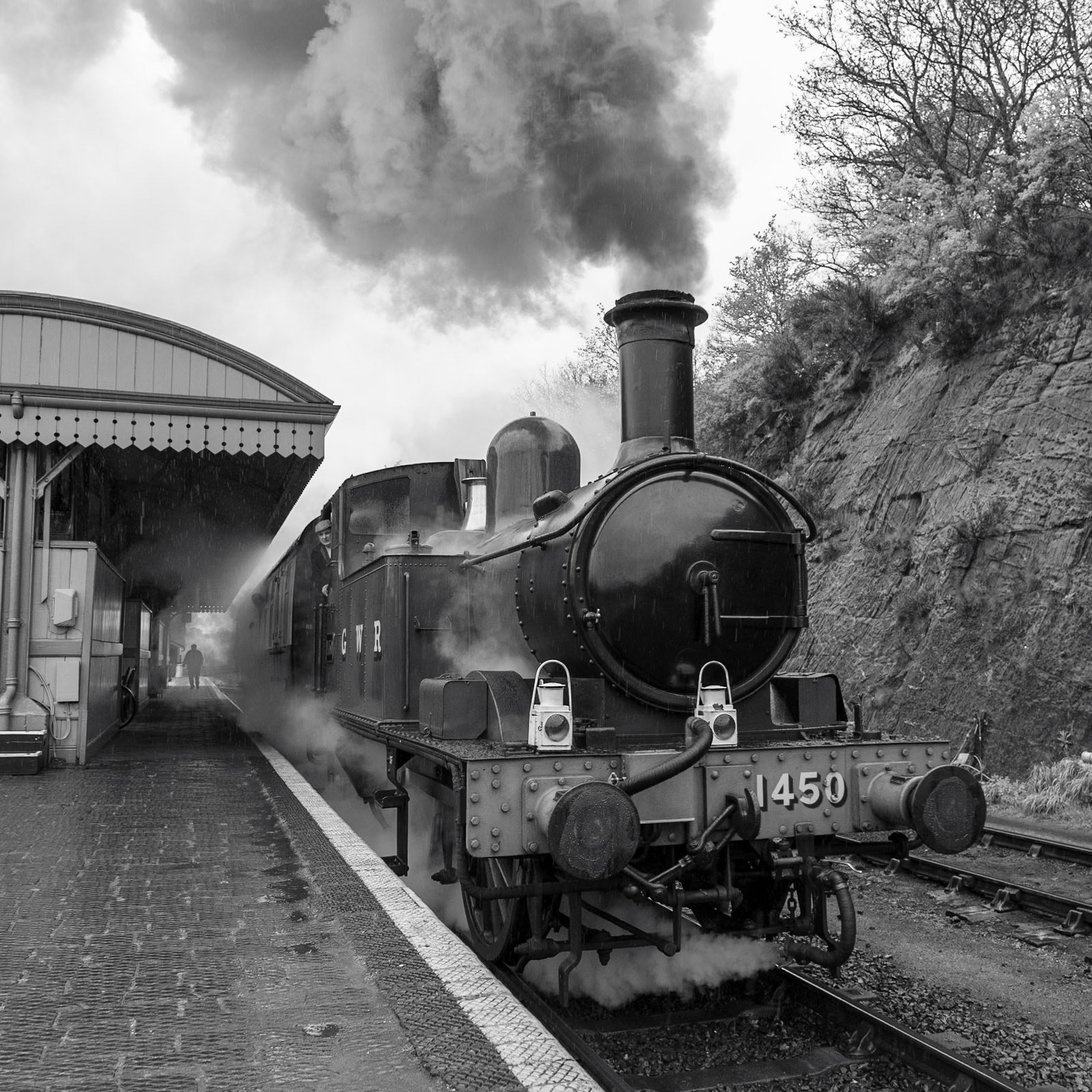 Steam escapes from diminuitive tank engine 1450 as it departs Bewdley station on a miserable spring morning with a charter train for Kidderminster.
