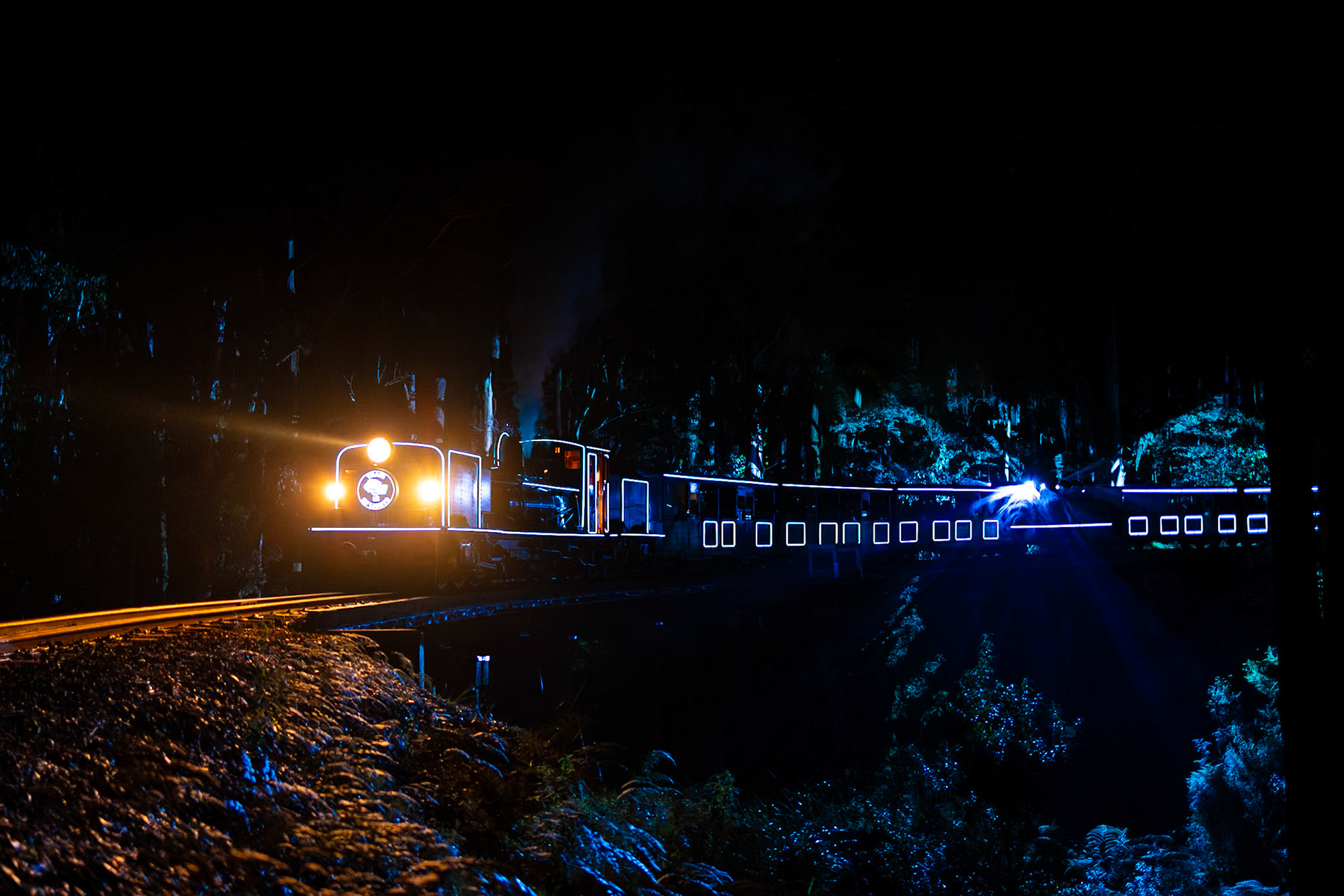 LED lights paint the valley floor as NG/G16 129 crosses the Wright trestle bridge with one of the Train of Lights specials.