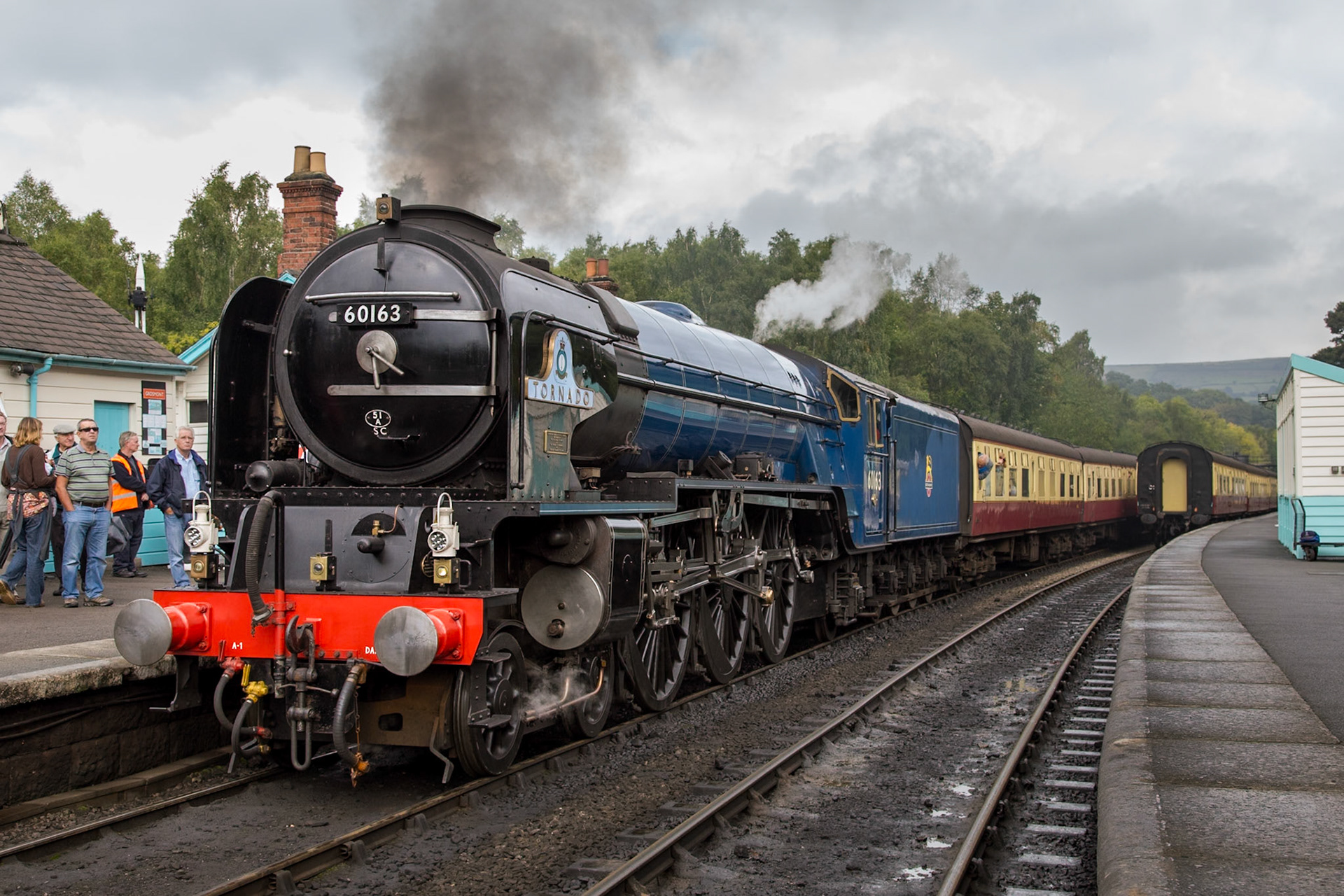 Newly-built A1 no. 60163 "Tornado" stands in platform 1 at Grosmont station as passengers board for Pickering.With construction commencing in 1994, "Tornado" is the first mainline steam locomotive to be built in the UK since 1960 and was launched into service in 2008. The locomotive is almost identical to other class members built, with only minor alterations made to accommodate cost, safety and operational requirements. This was taken on day one of the North Yorkshire Moors Railway's LNER Weekend in early October 2013.